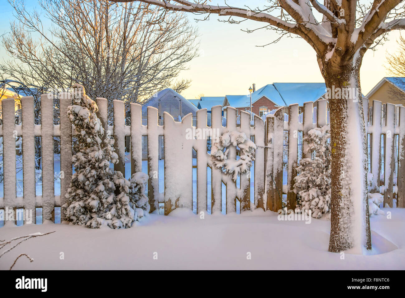 Un giardino cancello decorato con una ghirlanda di Natale tutto coperto di neve. Foto Stock