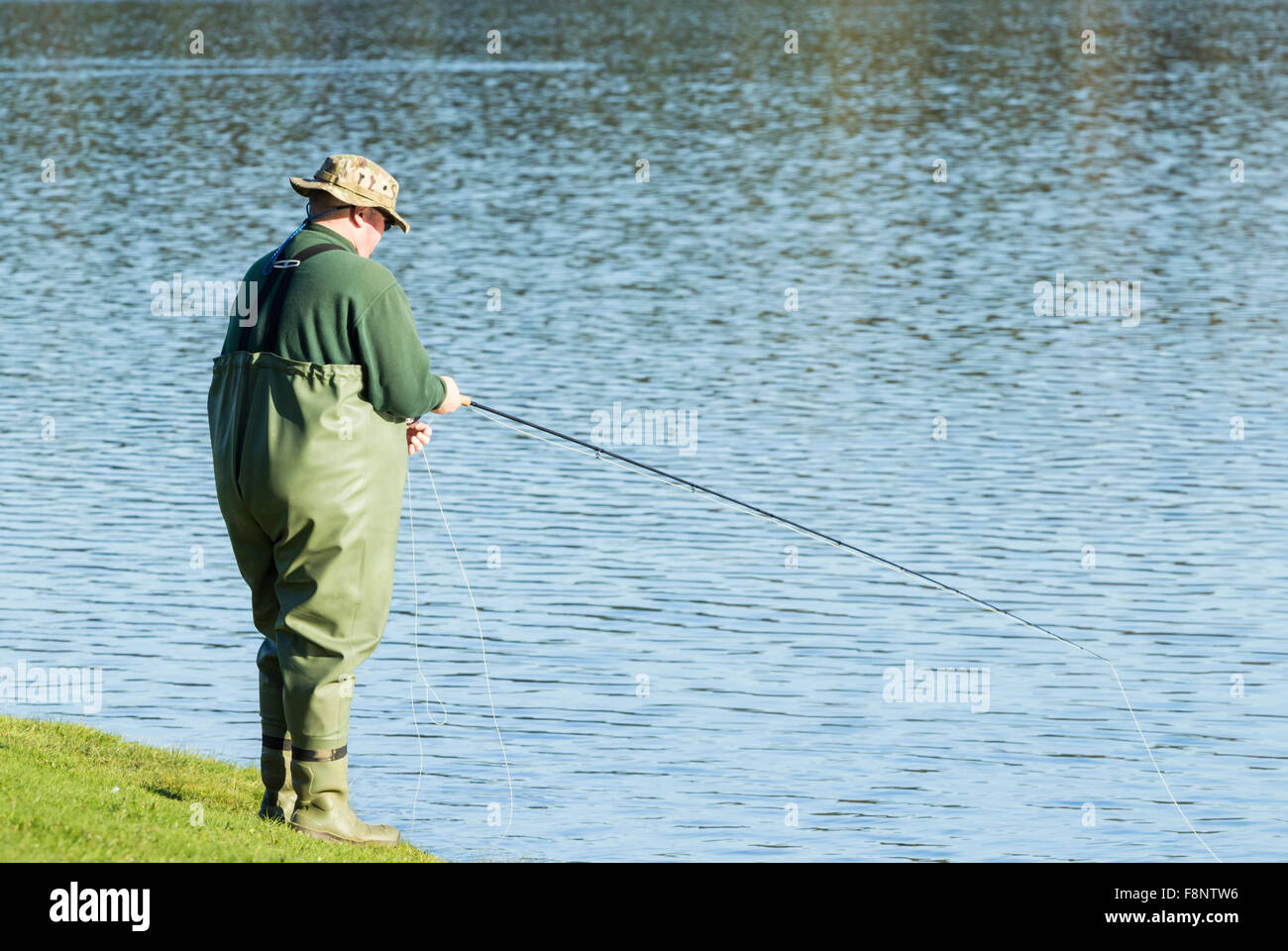 Uomo di Pesca a Mosca Report di Pesca su serbatoio Foto Stock