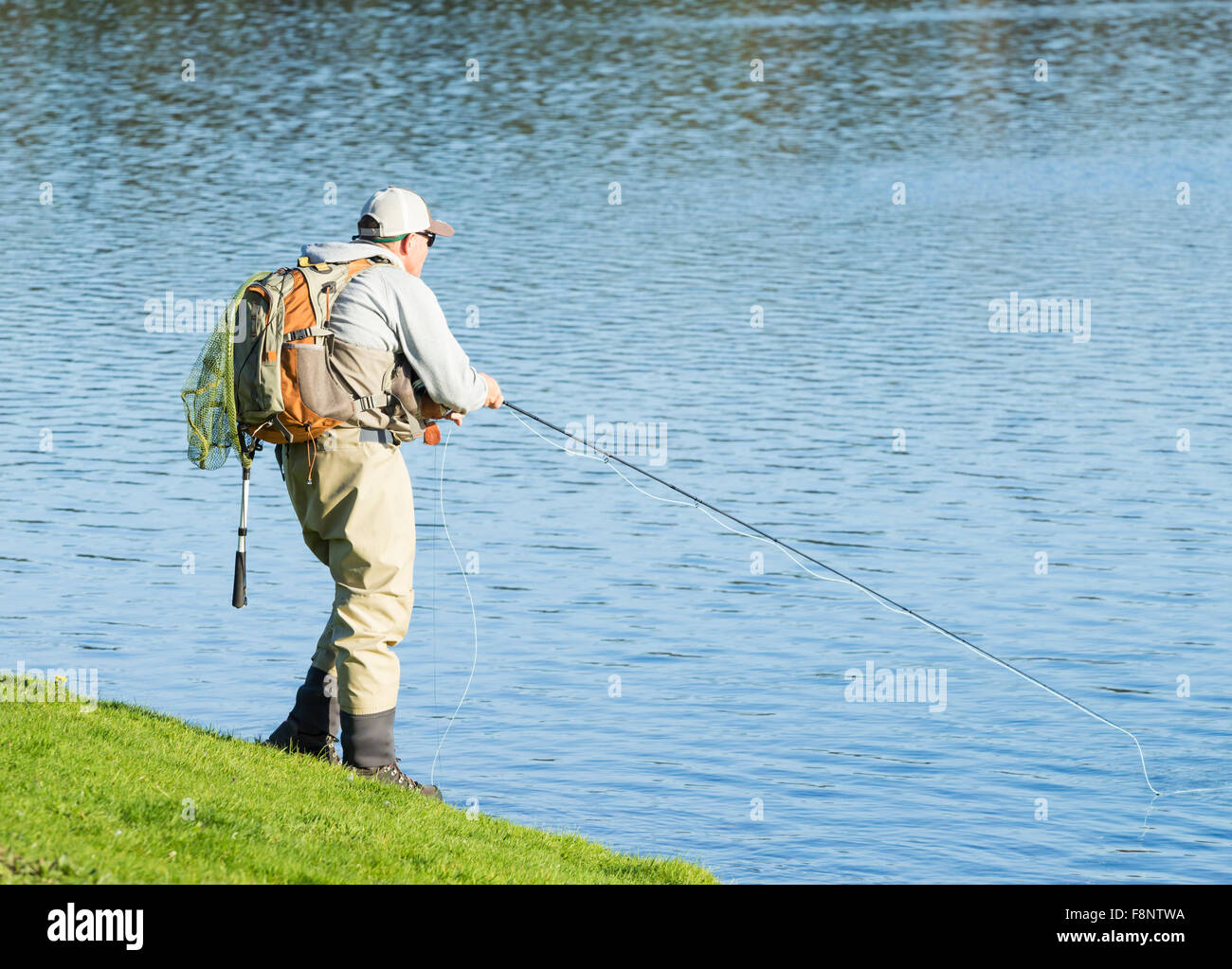 Uomo di Pesca a Mosca Report di Pesca su serbatoio Foto Stock