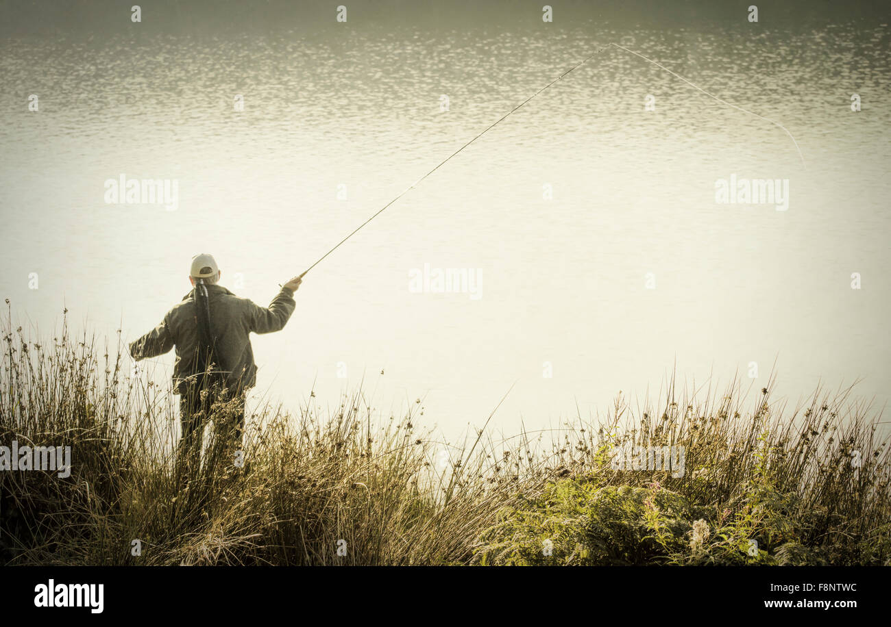 Uomo di Pesca a Mosca Report di Pesca su serbatoio Foto Stock