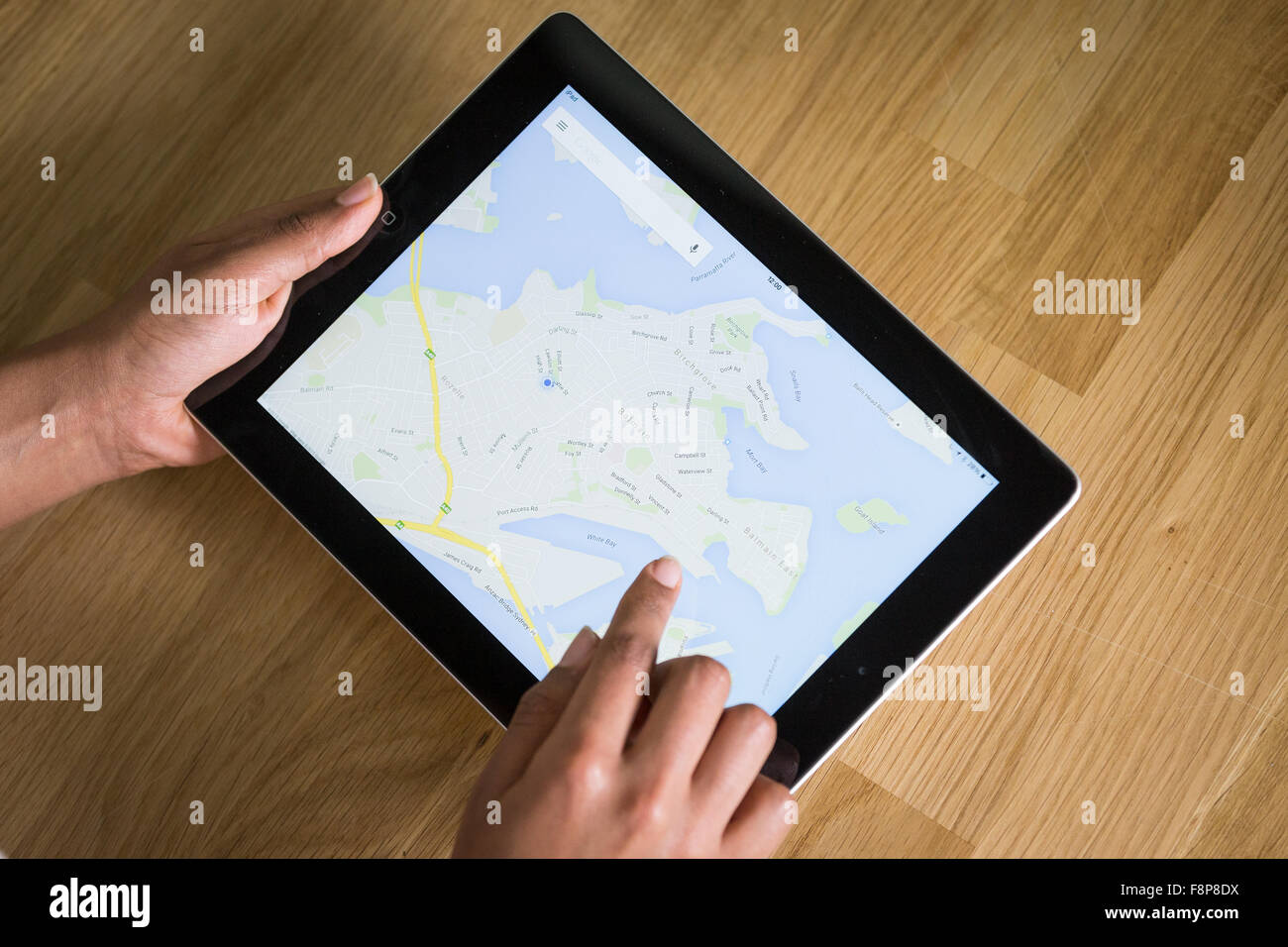 Un giovane di mixed-gara donna utilizzando una mappatura app su un tablet Foto Stock