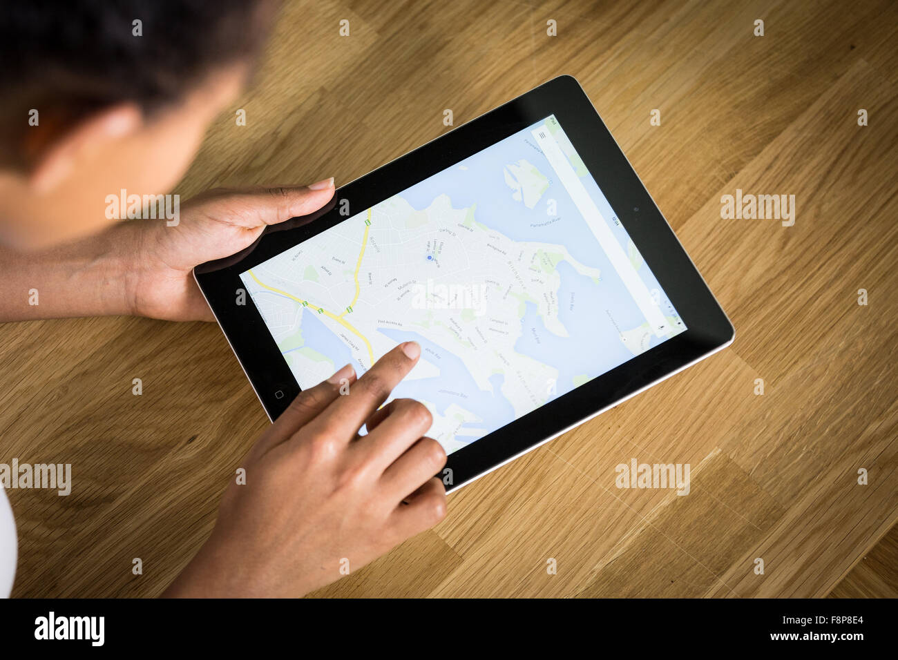 Un giovane di mixed-gara donna utilizzando una mappatura app su un tablet Foto Stock