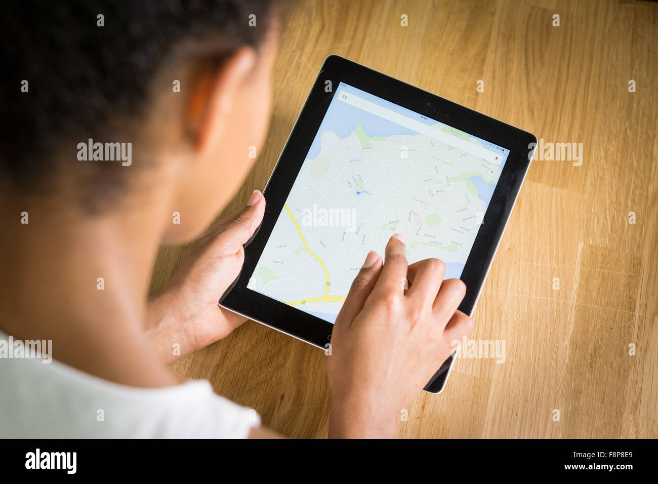Un giovane di mixed-gara donna utilizzando una mappatura app su un tablet Foto Stock