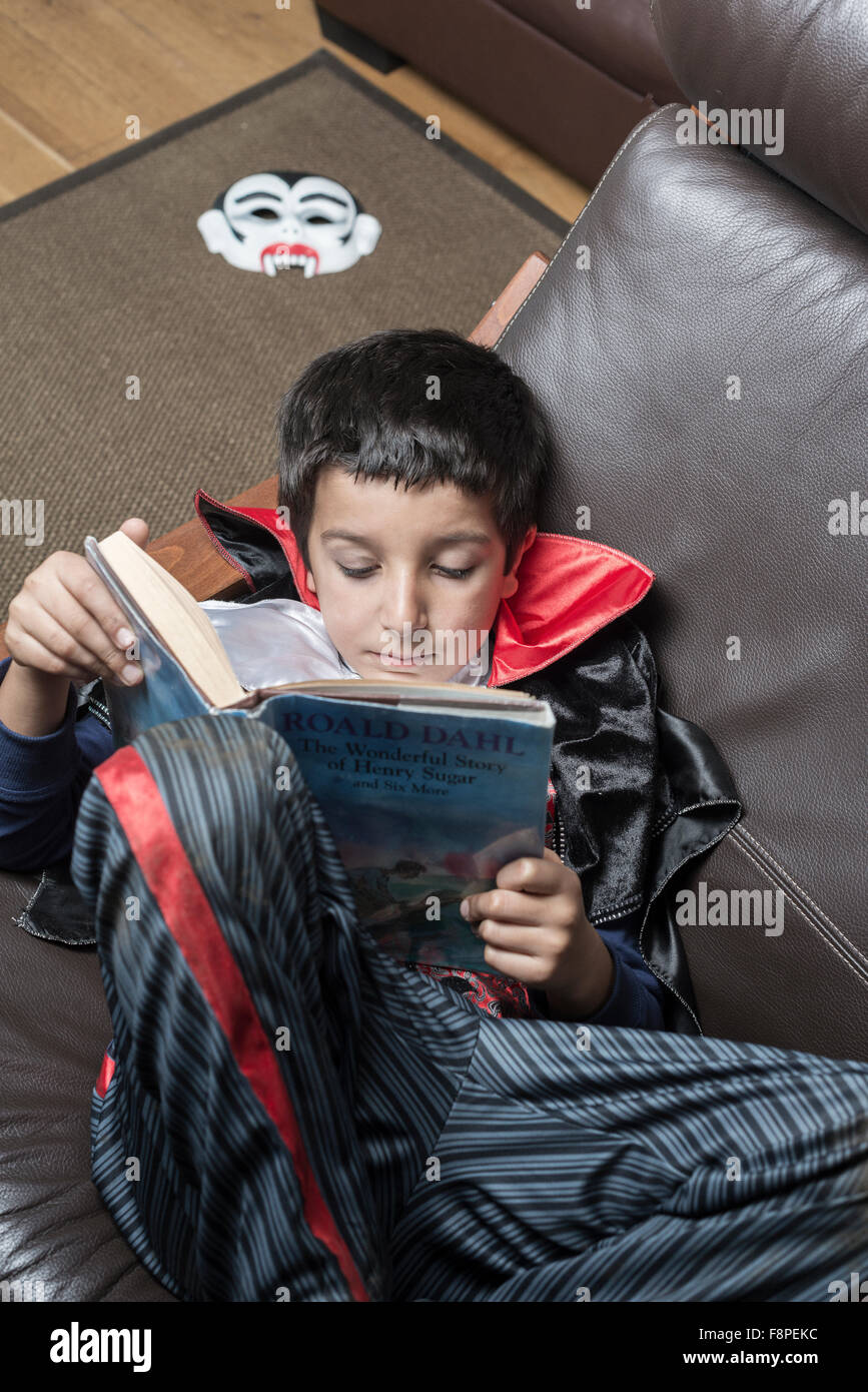 Ragazzo,8,in abito di Halloween la lettura di un libro Foto Stock