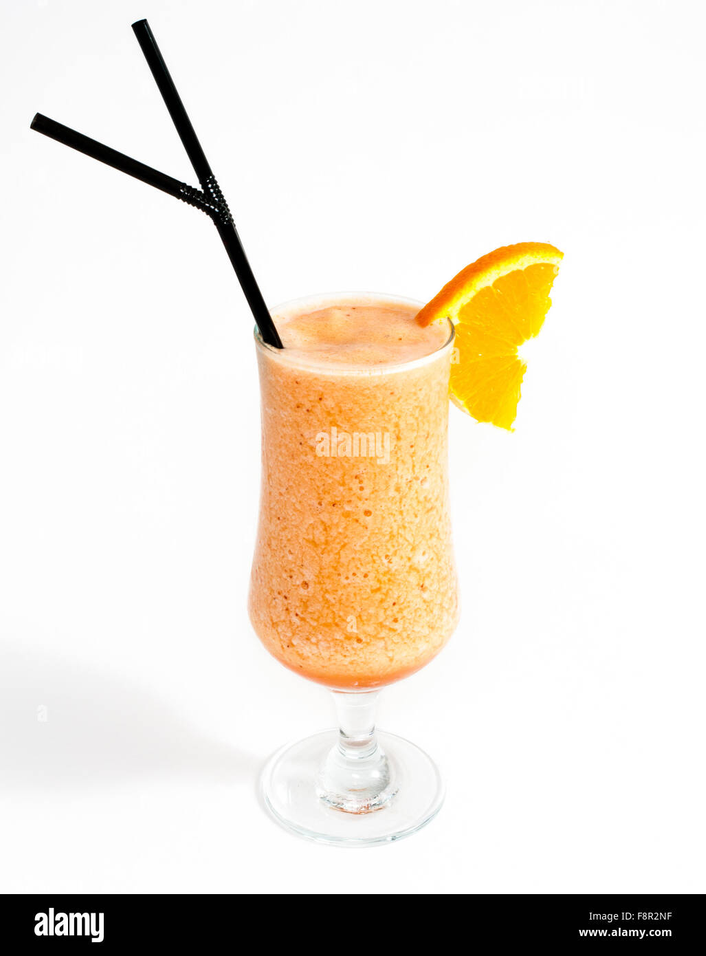 Close-up di uragano di vetro riempita con il frullato di arancia, decorata con due cannucce di nero e uno arancione Foto Stock