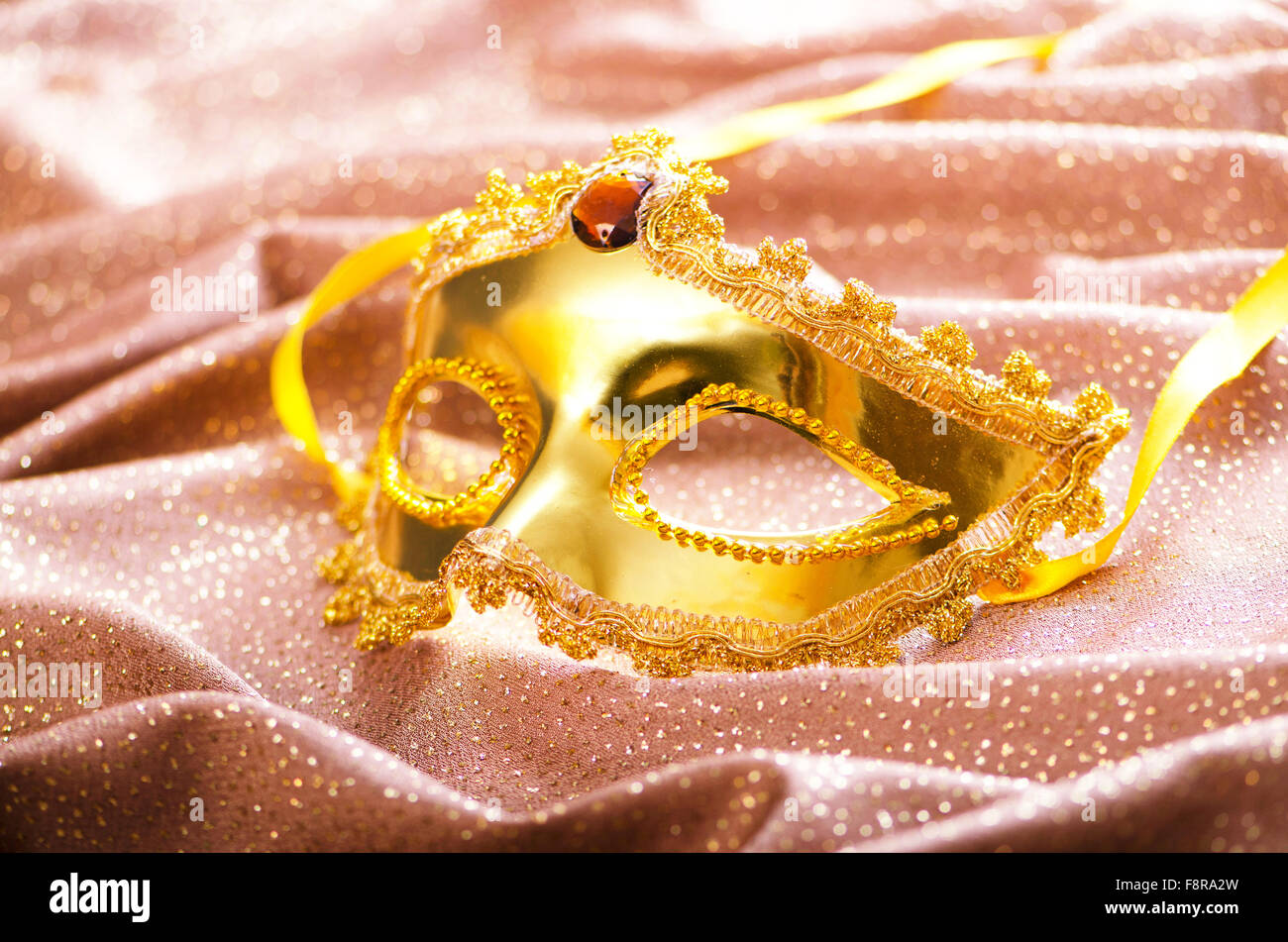 Maschera d'oro su sfondo satinato Foto Stock