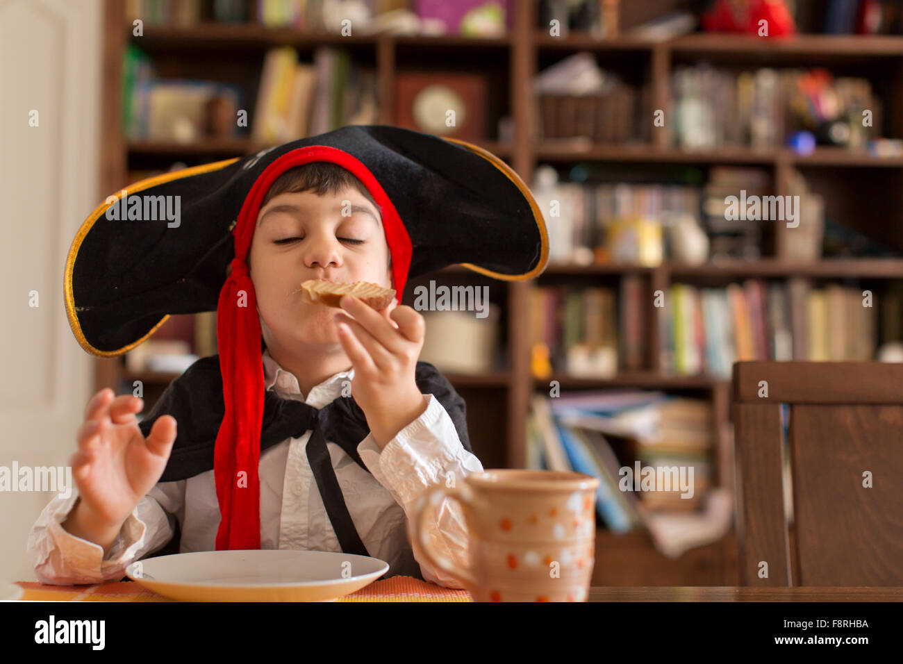 Ragazzo giovane vestito come pirati mangiare panino Foto Stock