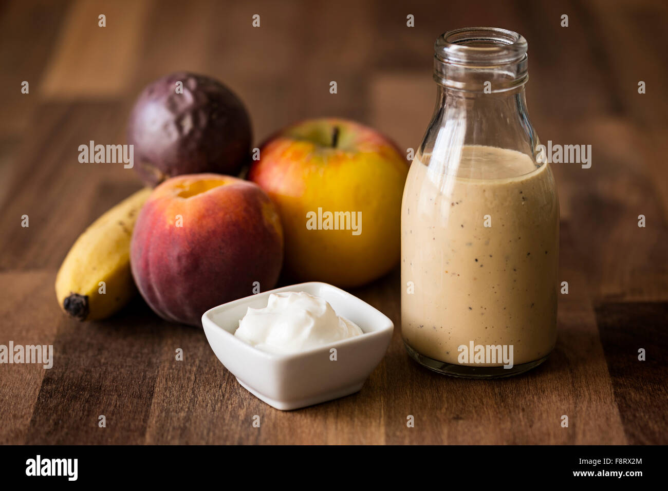 Frullato di salute fatta con banana, mela, pesca, frutto della passione e  yogurt smoothie presentato in una miniatura retrò bottiglia di latte Foto  stock - Alamy