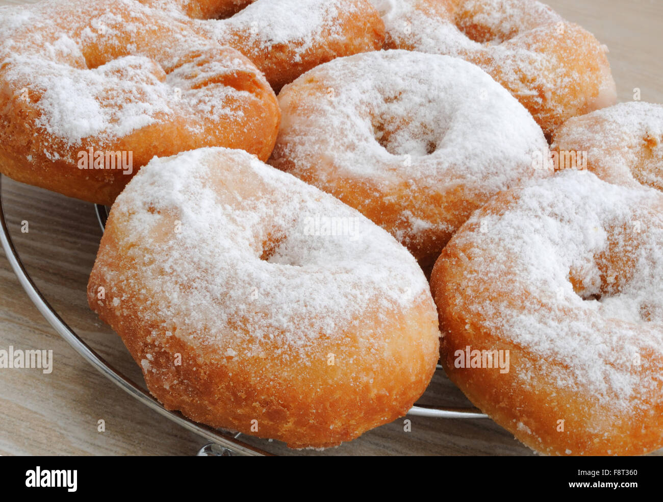 Le ciambelle fritte con lo zucchero a velo in un close-up sul supporto Foto Stock