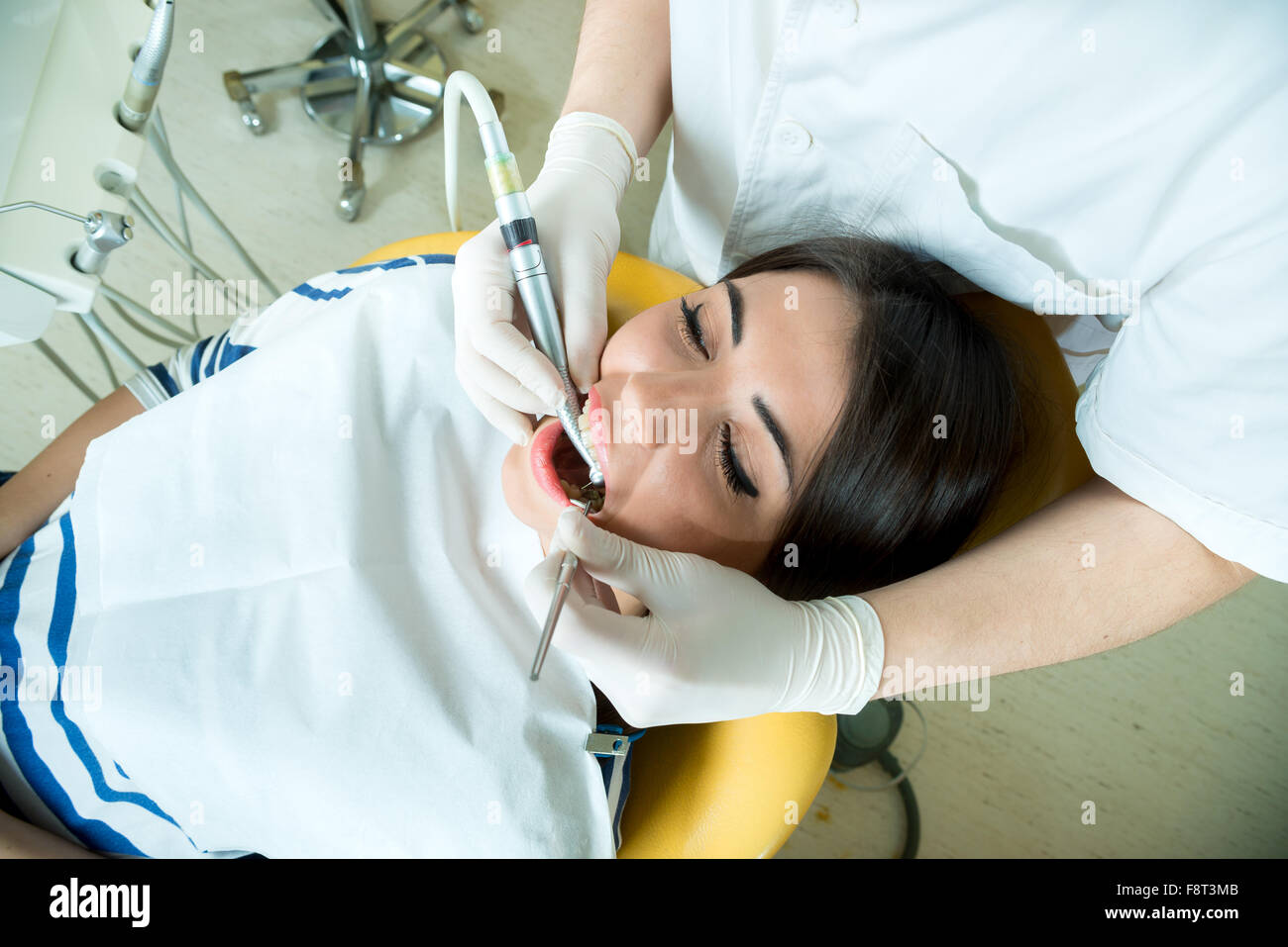 Giovani donne per il dentista nel riunito dentale si siede accanto a un medico per fare il dentista per vedere se i suoi denti erano in buone condizioni Foto Stock