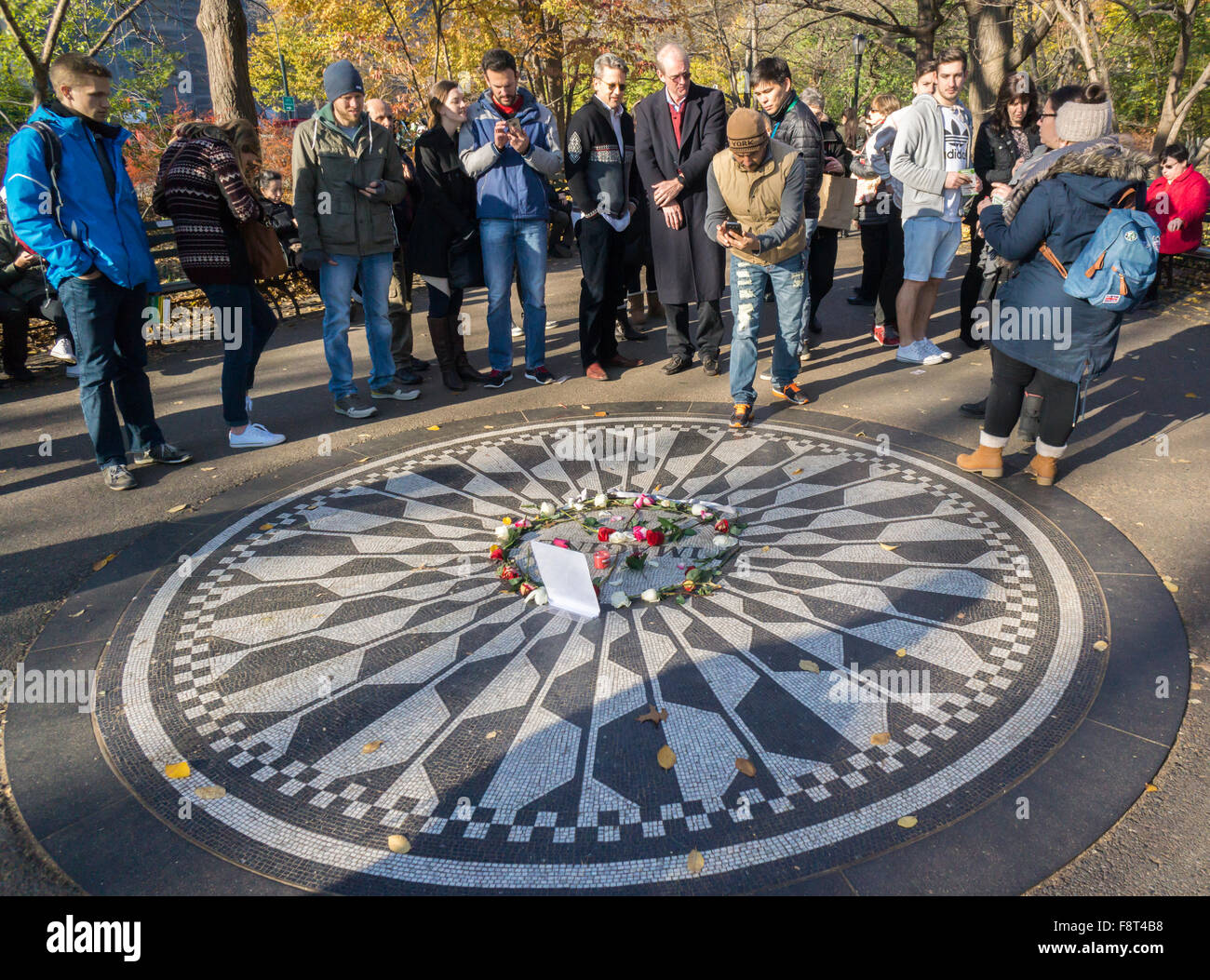 Turisti visitano Strawberry Fields a Central Park il 6 dicembre 2015 in anticipo del il trentacinquesimo anniversario di John Lennon la morte. Lennon è stato girato al di fuori di casa sua nel Dakota Apartments by impazzito pistolero David Chapman su dicembre 8, 1980. ( © Richard B. Levine) Foto Stock