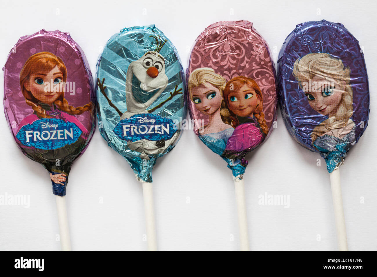 M&S 4 lollies cioccolato lecca lecca stagnola avvolto con caratteri diversi da Disney congelati impostato su sfondo bianco Foto Stock