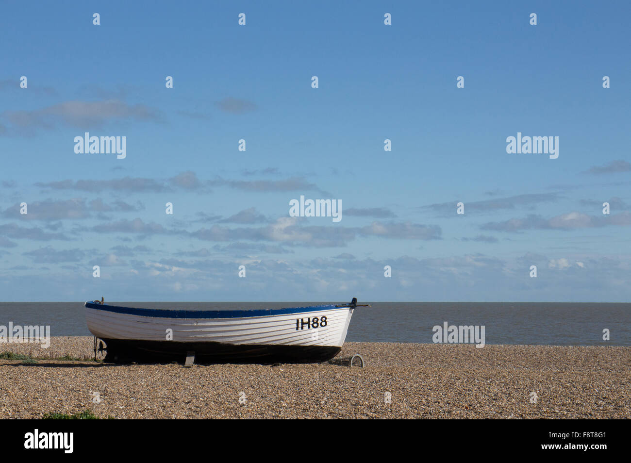 Legno bianco barche da pesca sulla spiaggia di ciottoli contro un cielo blu a Aldeburgh Suffolk in Inghilterra Foto Stock