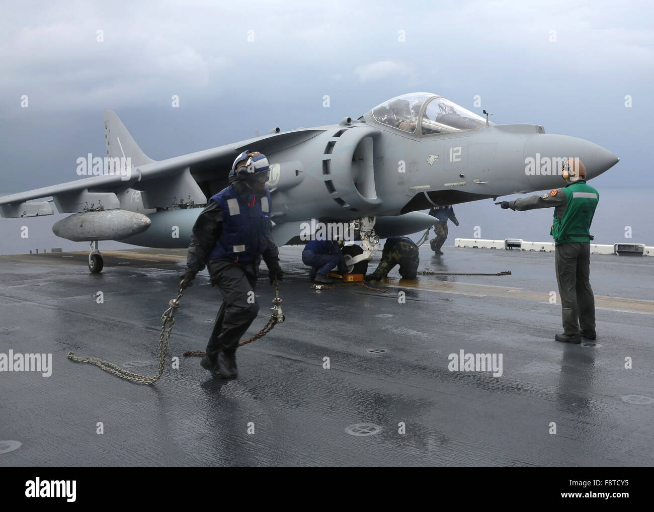 I marinai Rimuovere tacchi e catene da un italiano AV-8B Harrier a bordo dell'assalto anfibio nave USS Kearsarge Foto Stock