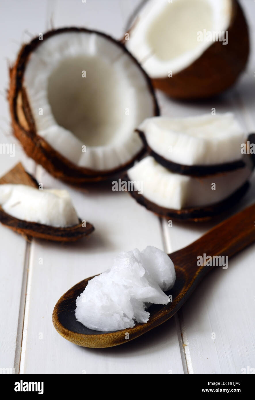 Noce di cocco con olio di noce di cocco in un cucchiaio Foto Stock