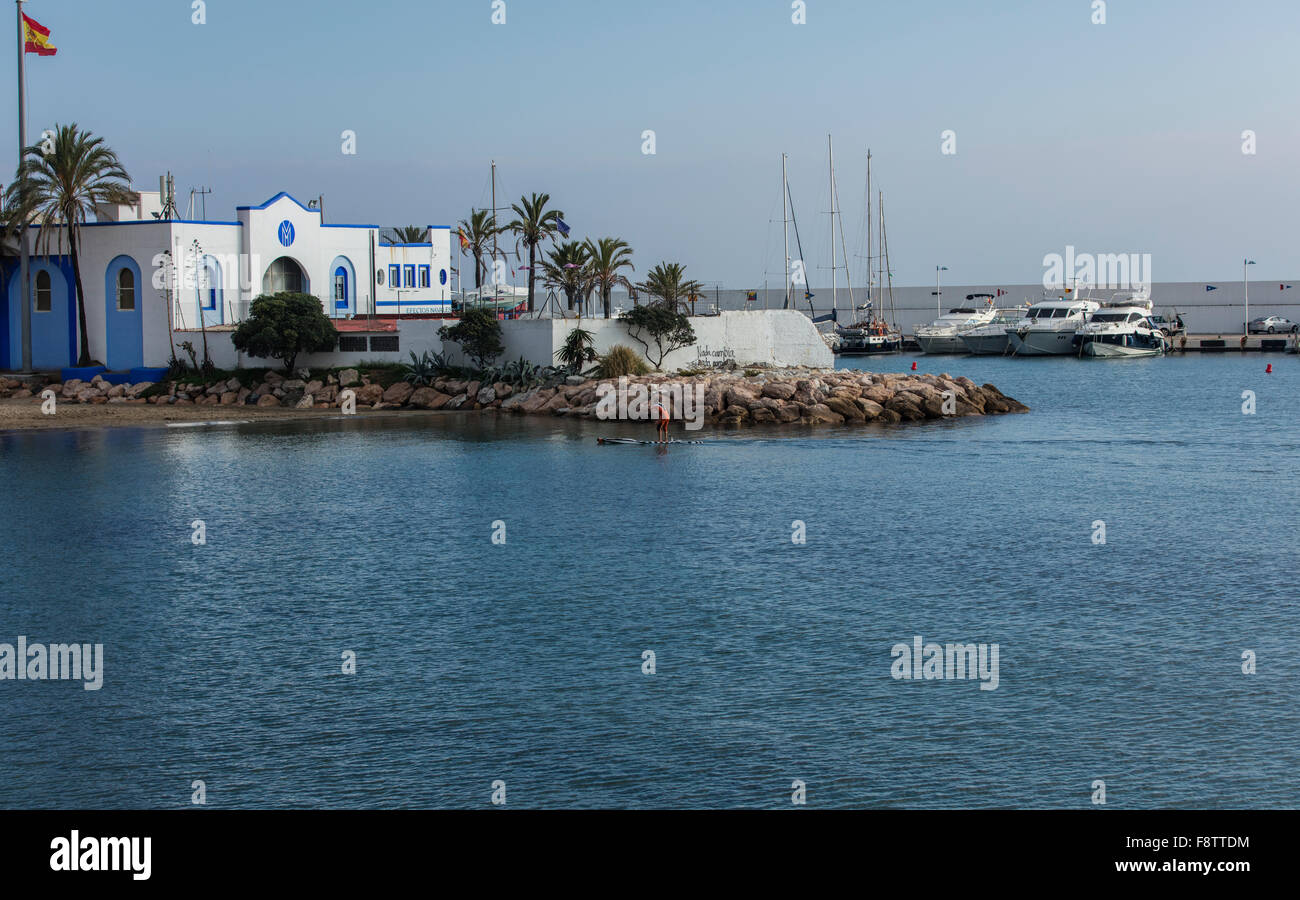 La costruzione presso il porto turistico di Marbella in Spagna con le imbarcazioni da diporto e la bandiera spagnola in volo da un montante Foto Stock