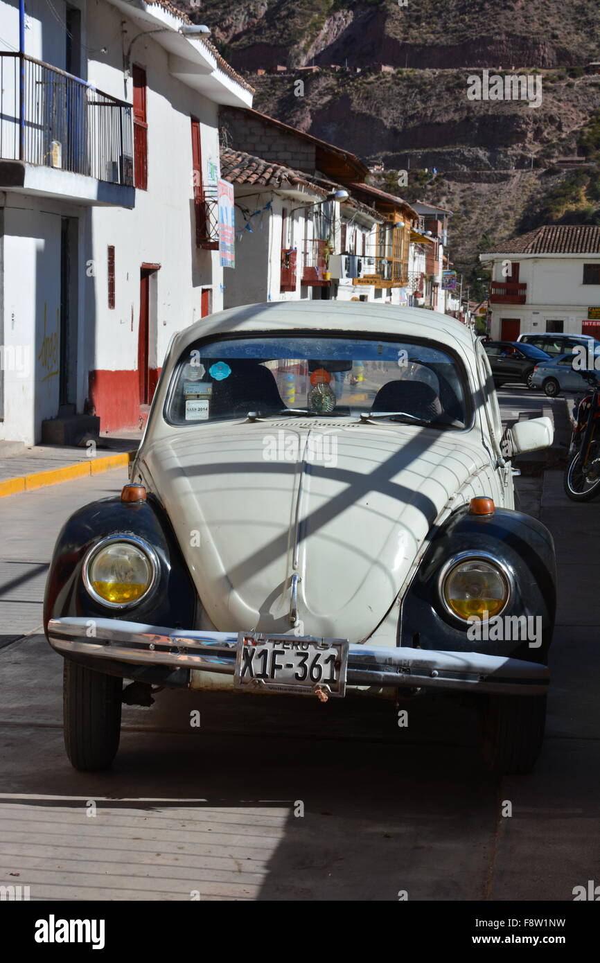 Un vecchio bianco e nero Vw Bug sulle strade di Urubamba Perù. Foto Stock
