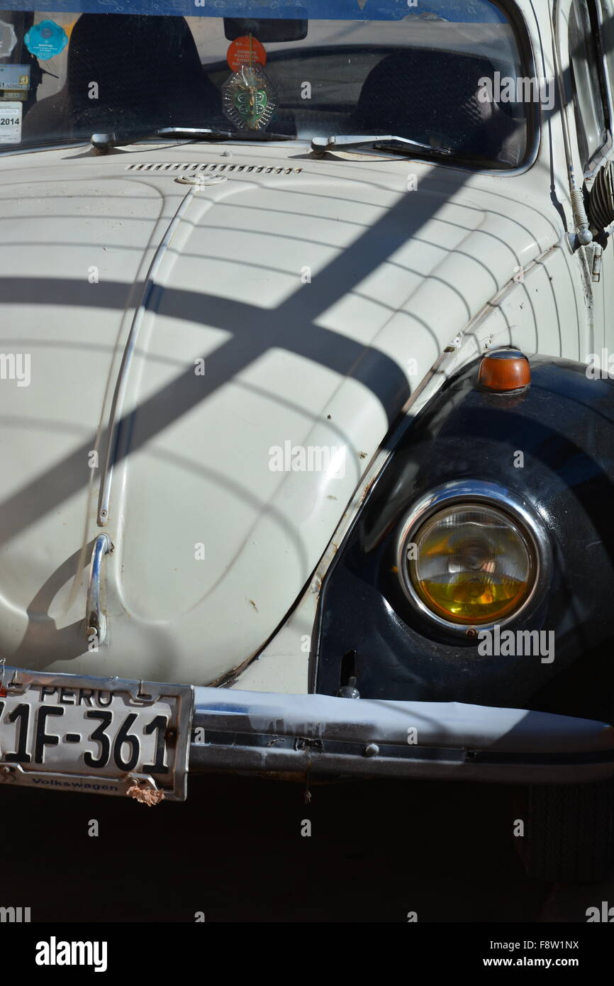 Un vecchio bianco e nero Vw Bug sulle strade di Urubamba Perù. Foto Stock