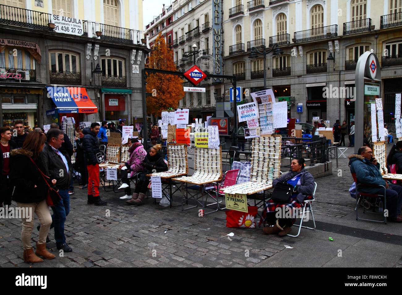 Madrid, Spagna 11 dicembre 2015: Venditori di biglietti della lotteria che vendono biglietti per la lotteria di Natale accanto ad un ingresso alla stazione della metropolitana Sol in Plaza Puerta del Sol nel centro di Madrid. La lotteria di Natale spagnola è una delle più antiche al mondo e la più grande al mondo in termini di pagamento totale. Il biglietto vincente è noto come "El Gordo" ("il grande" o "il grasso"). Crediti: James Brunker / Alamy Live News Foto Stock