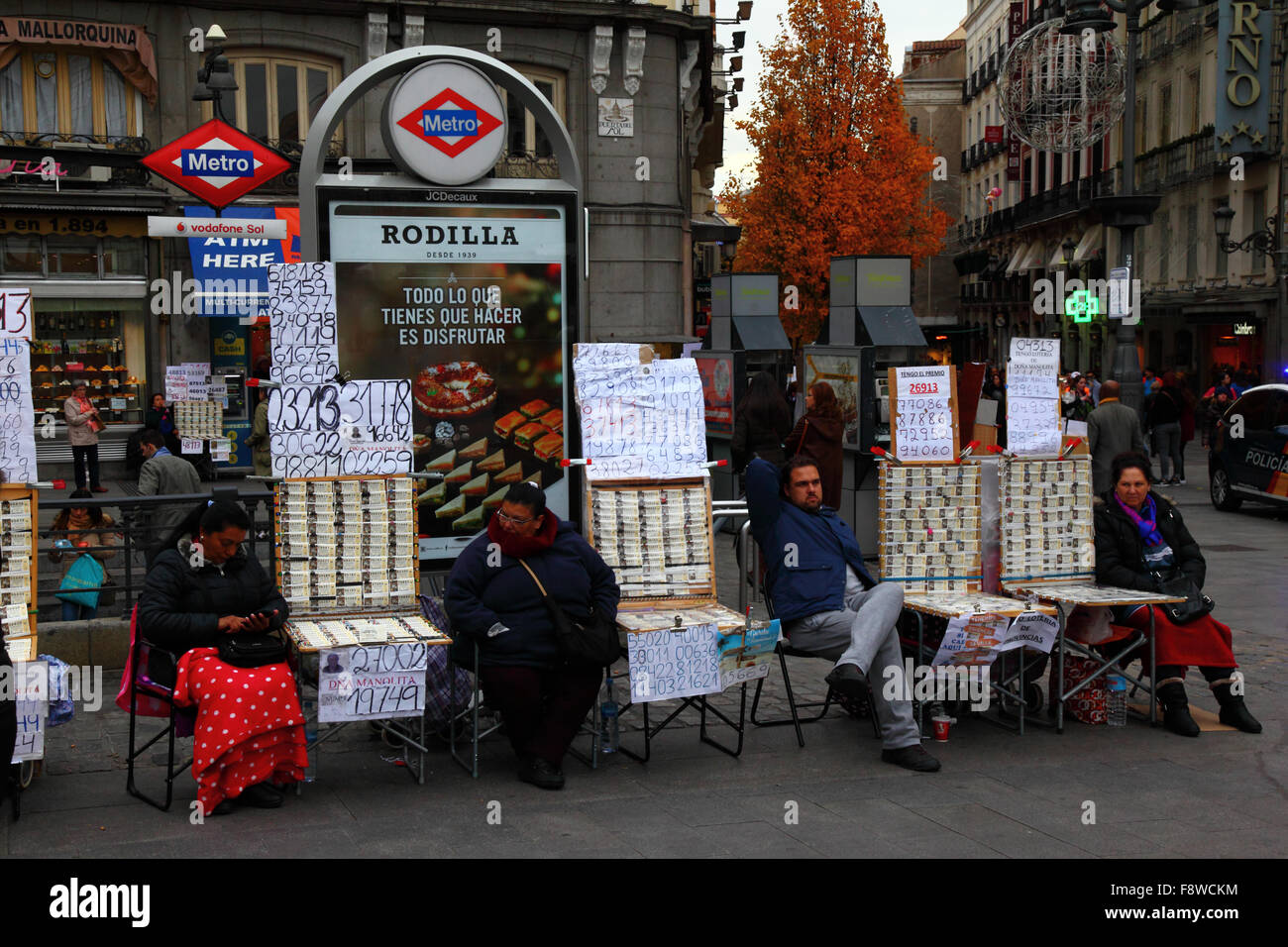 Madrid, Spagna 11 dicembre 2015: Venditori di biglietti della lotteria che vendono biglietti per la lotteria di Natale accanto ad un ingresso alla stazione della metropolitana Sol in Plaza Puerta del Sol nel centro di Madrid. La lotteria di Natale spagnola è una delle più antiche al mondo e la più grande al mondo in termini di pagamento totale. Il biglietto vincente è noto come "El Gordo" ("il grande" o "il grasso"). Crediti: James Brunker / Alamy Live News Foto Stock
