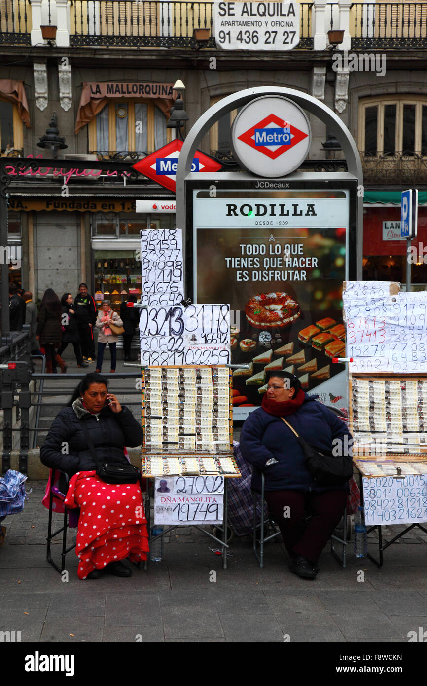 Madrid, Spagna 11 dicembre 2015: Donne che vendono biglietti per la lotteria di Natale accanto all'ingresso della stazione della metropolitana Sol in Plaza Puerta del Sol nel centro di Madrid. La lotteria di Natale spagnola è una delle più antiche al mondo e la più grande al mondo in termini di pagamento totale. Il biglietto vincente è noto come "El Gordo" ("il grande" o "il grasso"). Crediti: James Brunker / Alamy Live News Foto Stock