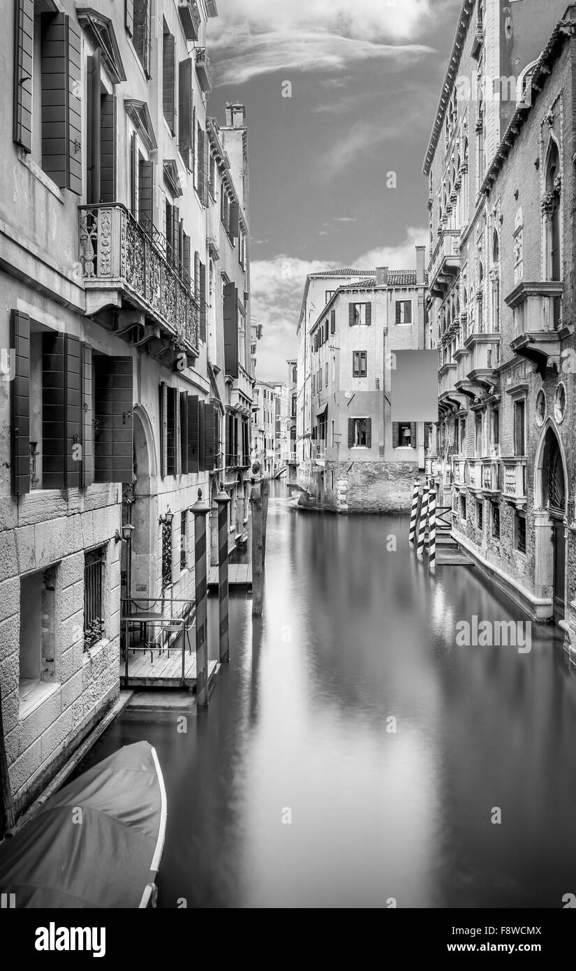 B&W stretto canale con acqua di seta a Venezia, Italia Foto Stock