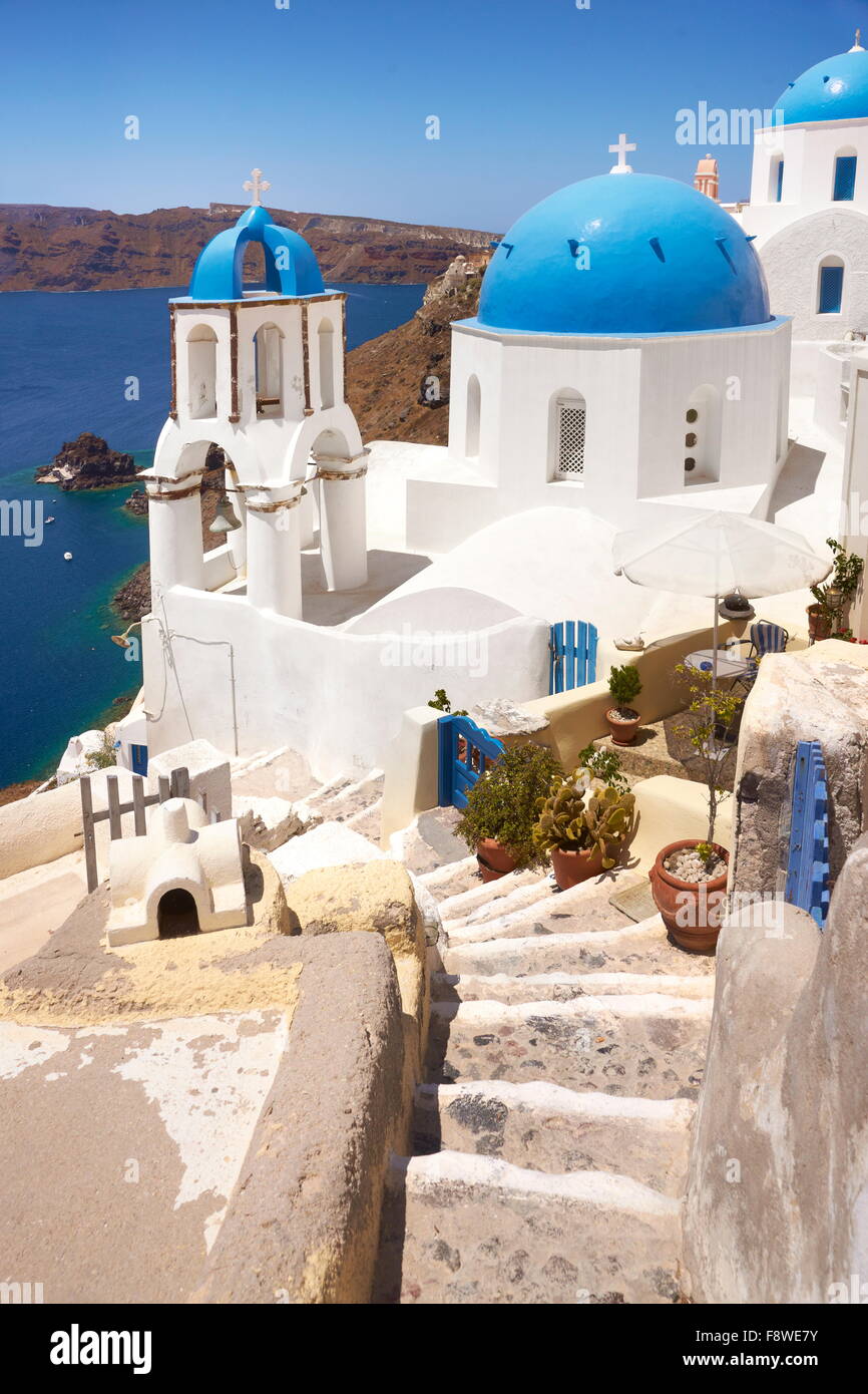 Paesaggio con greca chiesa bianca che si affaccia sul mare e la cittadina di Oia - Santorini Island, Grecia Foto Stock