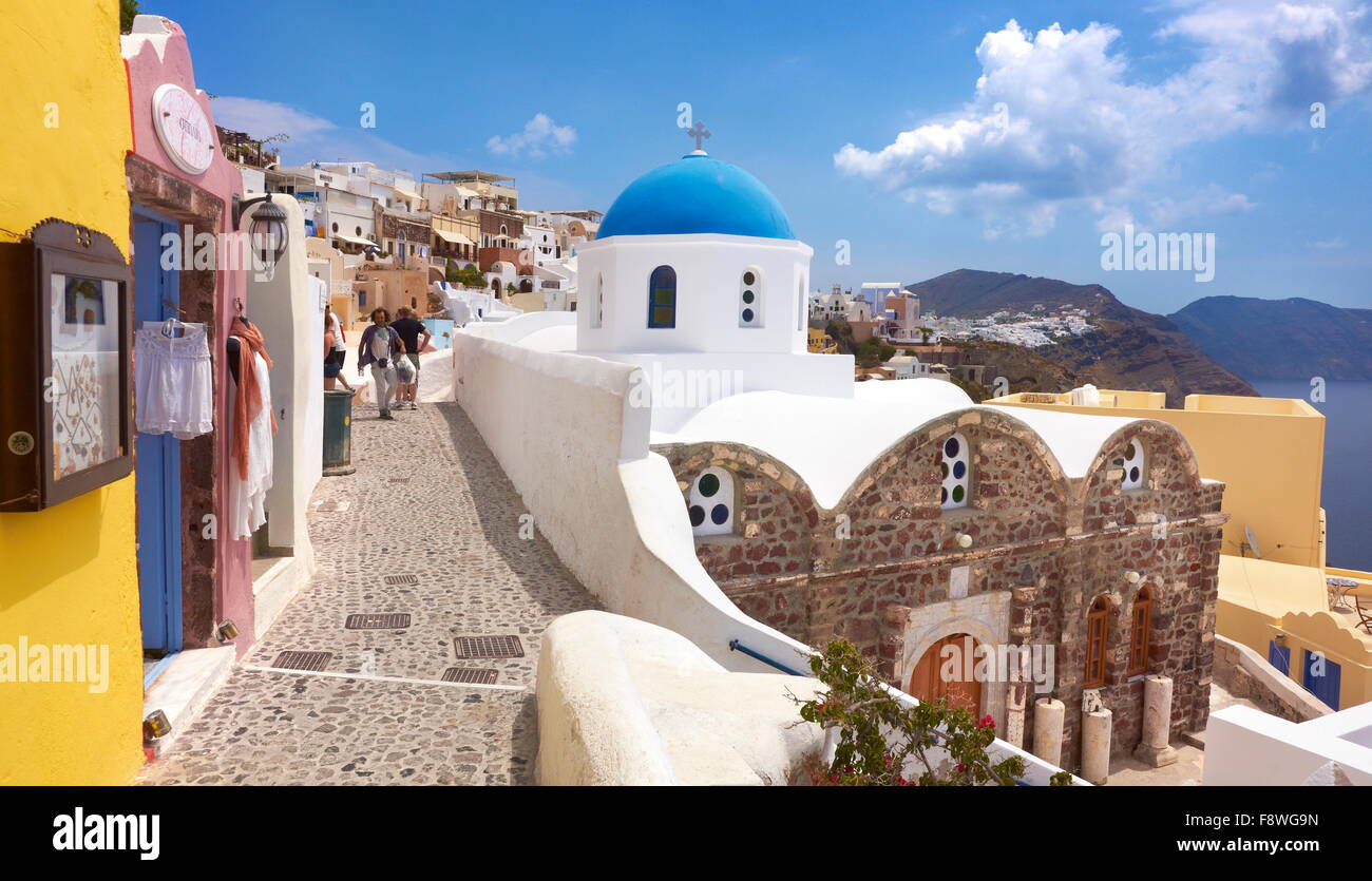 Vista in passeggiata con negozi e greco bianco chiesa - la cittadina di Oia, isola di Santorini, Cicladi, Grecia Foto Stock