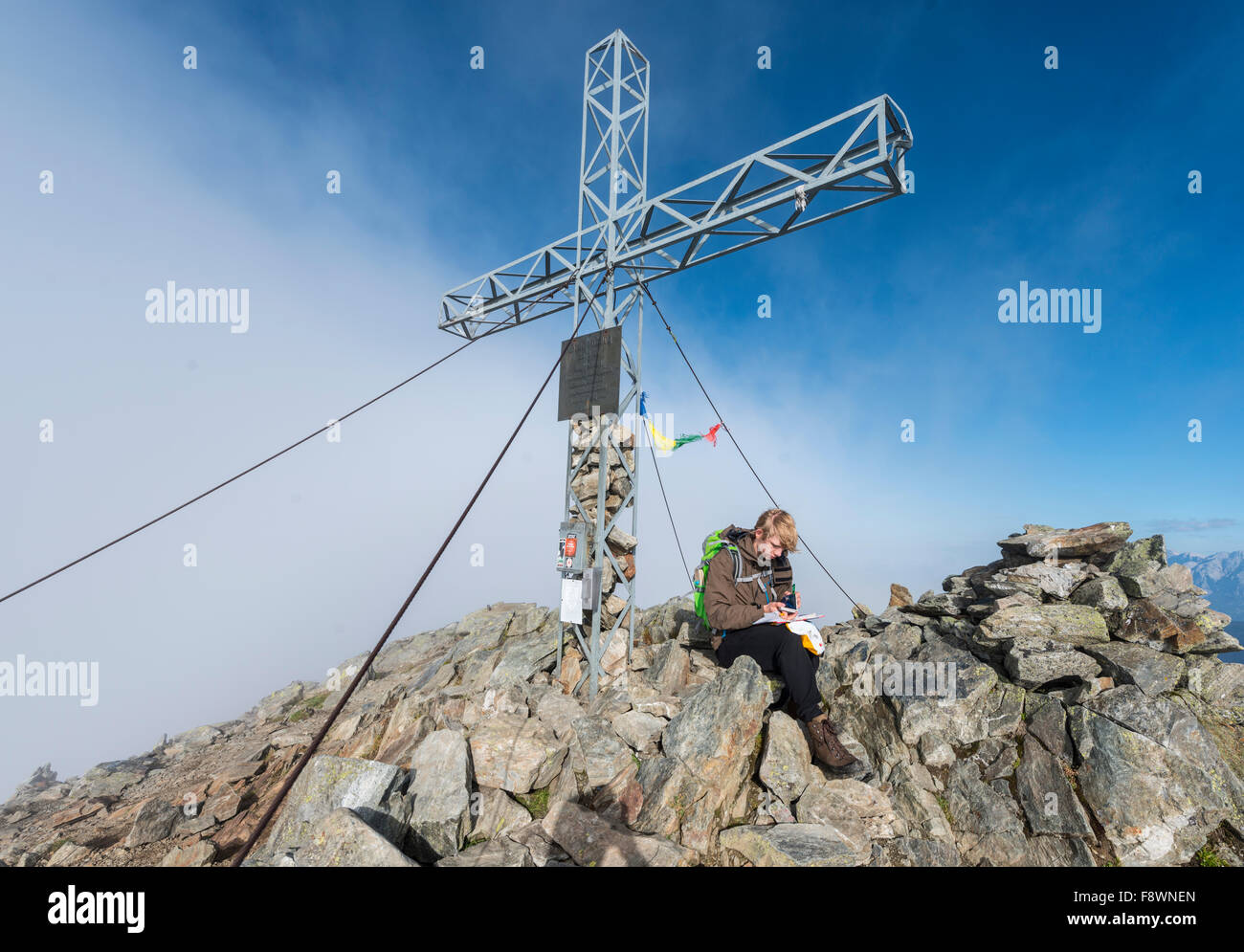 Escursionista scrivere nel giornale di bordo al vertice, Greifenberg, 2618m, Rohrmoos-Untertal, Schladminger Tauern, Stiria, Austria Foto Stock