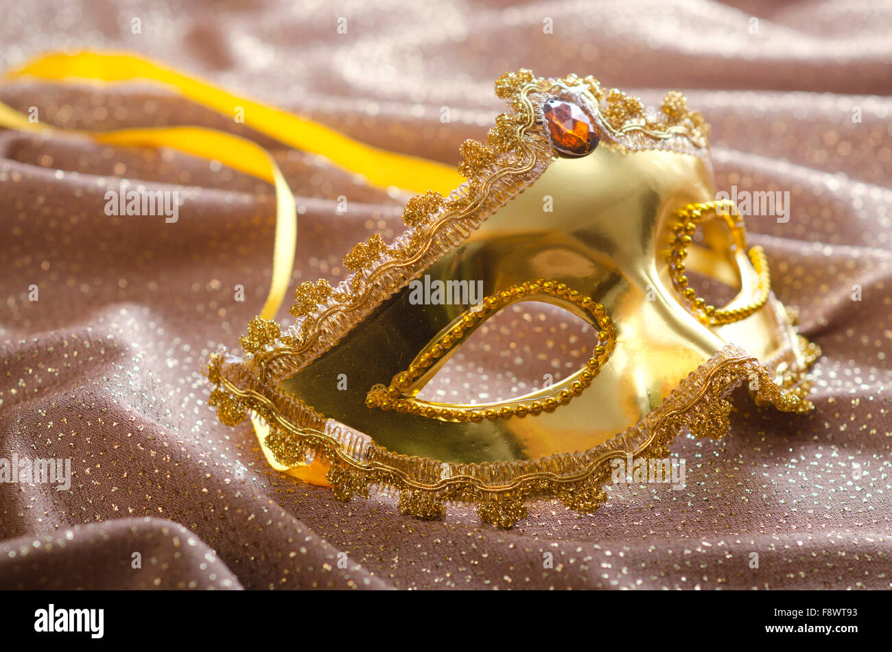 Maschera d'oro su sfondo satinato Foto Stock
