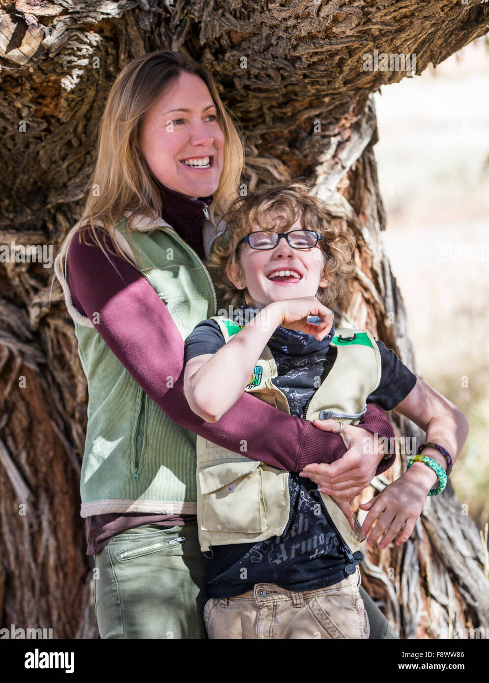 Attraente madre; giovane figlio posa per fotografie di albero su ranch Foto Stock