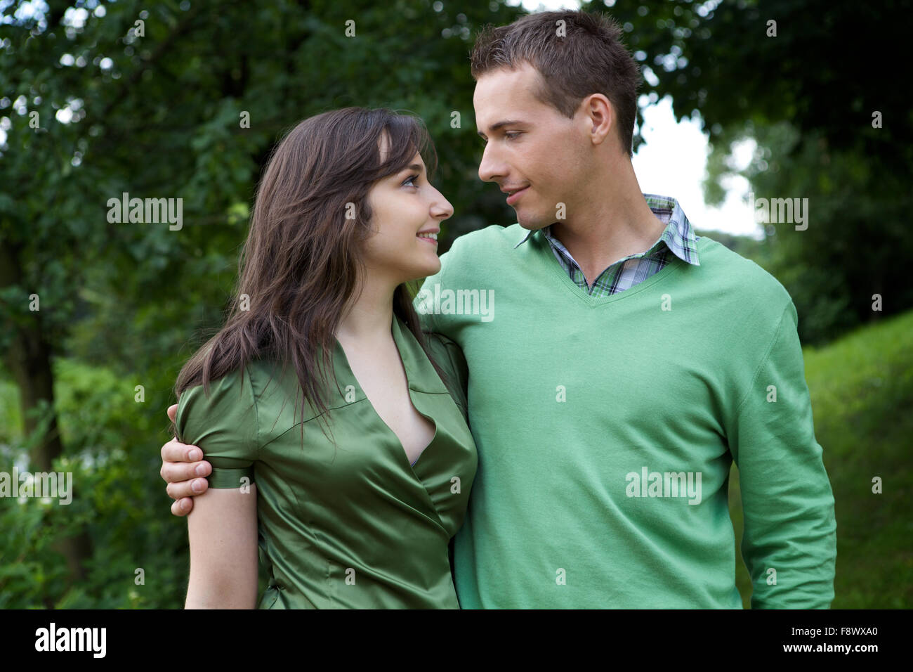 Coppia giovane con braccio intorno e guardando ogni altro Foto Stock