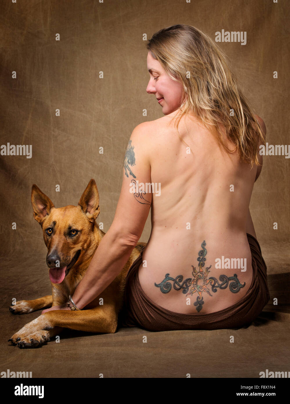 Ritratto in studio di tatuaggi su una splendida bionda pelose parzialmente  nudo di donna con il suo cane Foto stock - Alamy