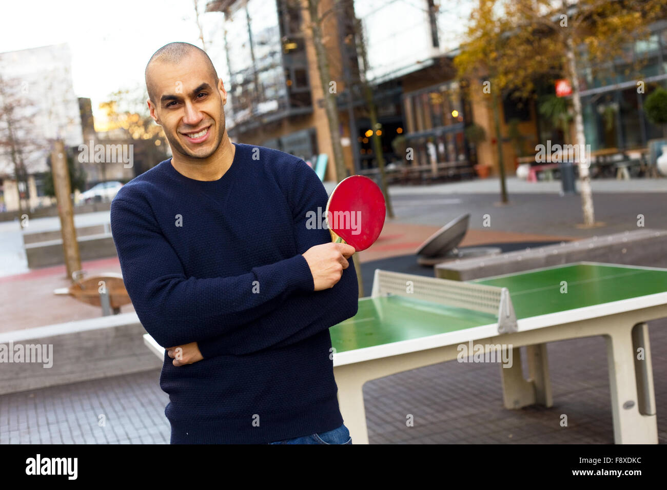 Giovane uomo in posa tenendo una tabella racchetta da tennis Foto Stock