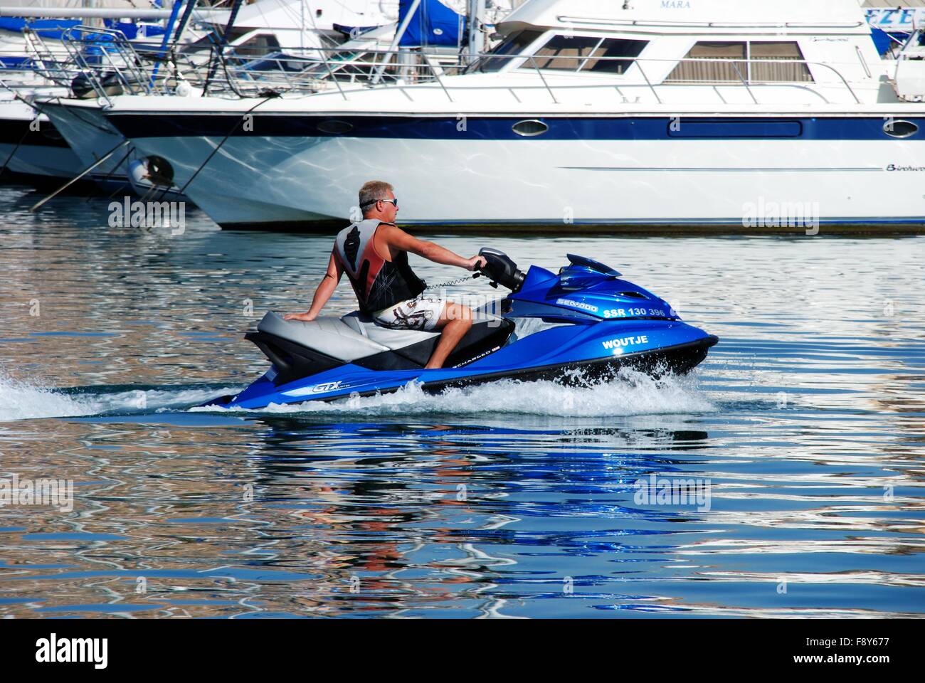 Un uomo su un jet ski in porto, Fuengirola, provincia di Malaga, Andalusia, Spagna, Europa occidentale. Foto Stock