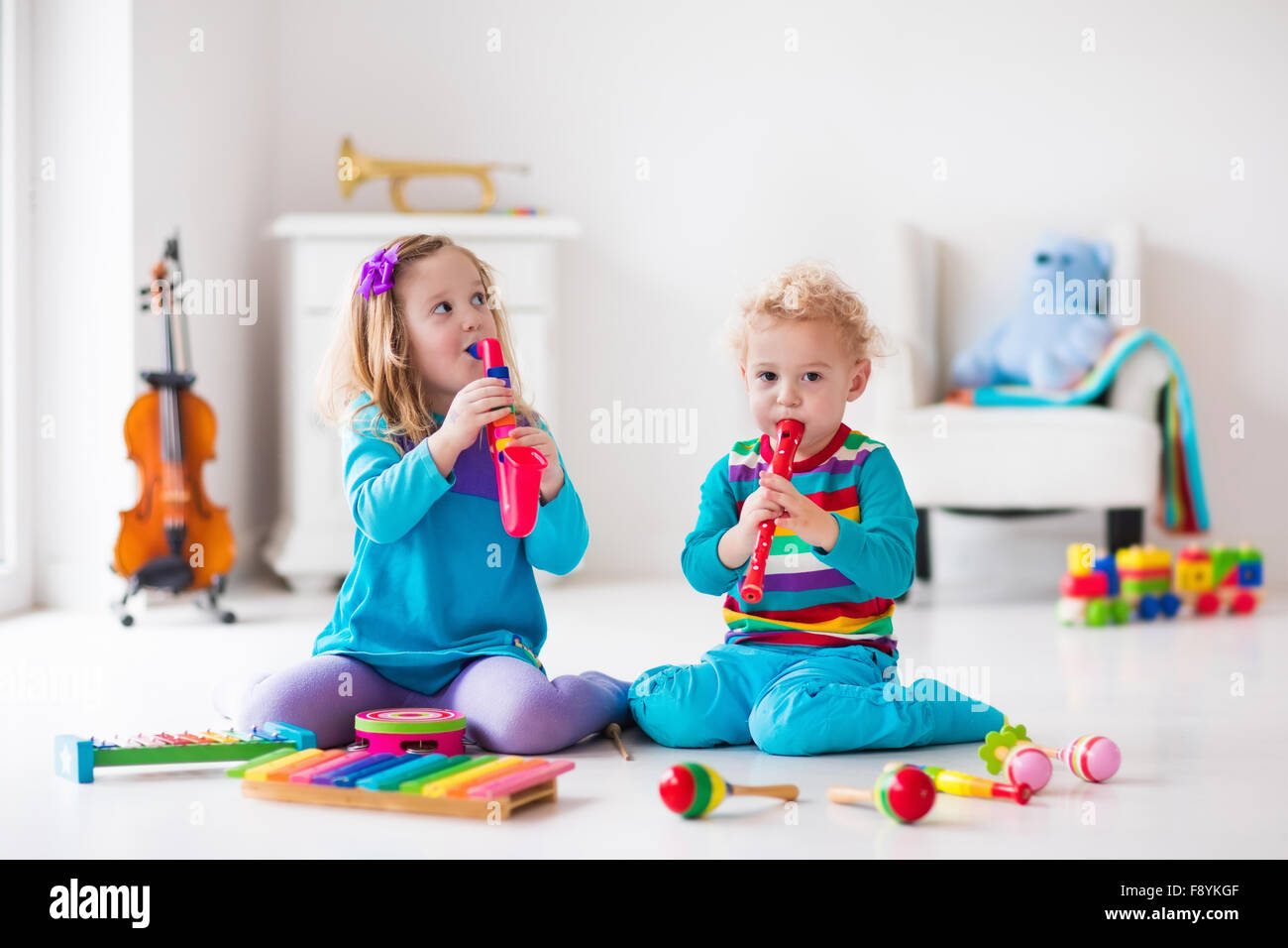 I bambini con strumenti musicali. Educazione musicale per i bambini. In legno colorato giocattoli d'arte. Bambina e ragazzo riprodurre musica. Foto Stock