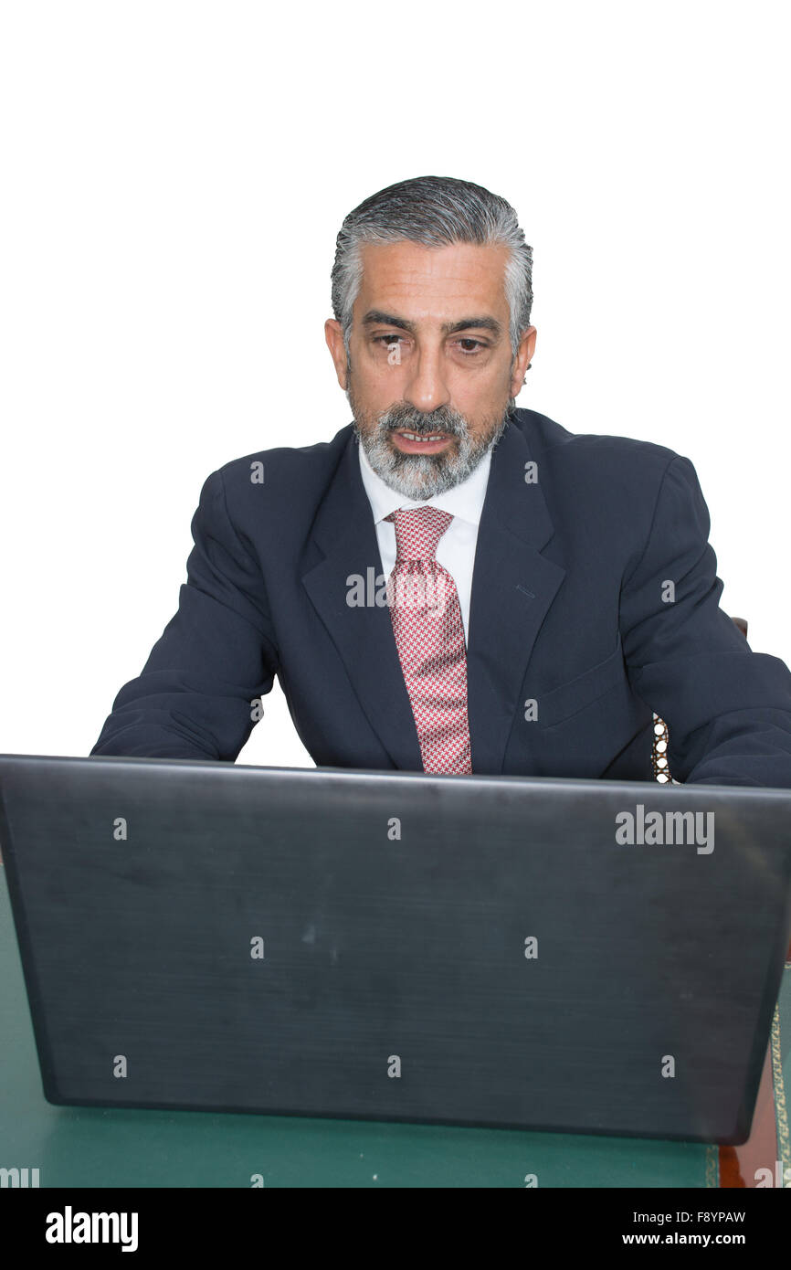 Imprenditore in un vestito e cravatta, nel suo studio. Alla scrivania, utilizzando il PC. Foto Stock