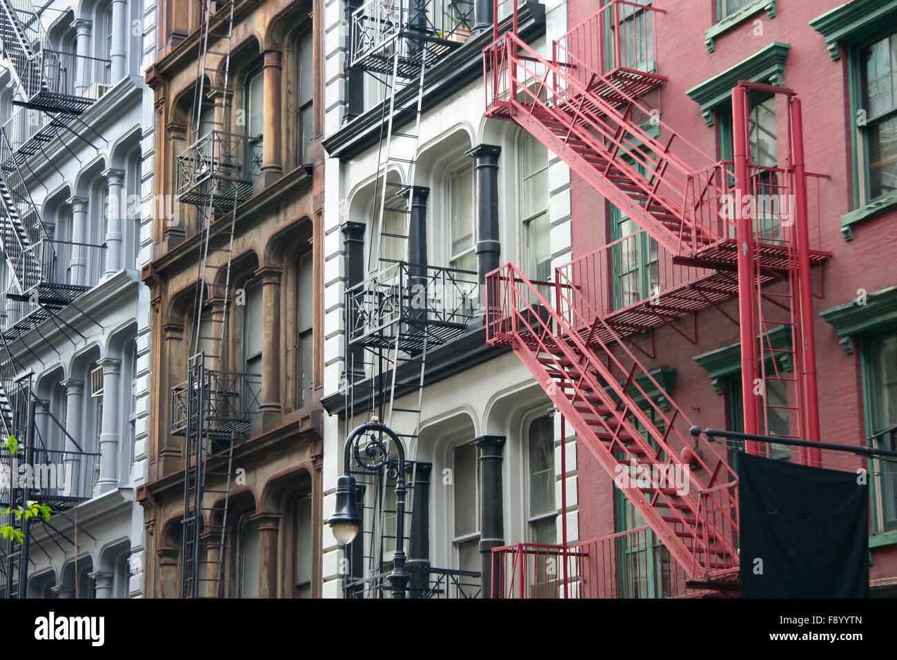 Quattro coloratissimi, blu, marrone, bianco e rosso appartamento facciate di edifici con fughe di emergenza. Tipico di New York City biciclette compl Foto Stock