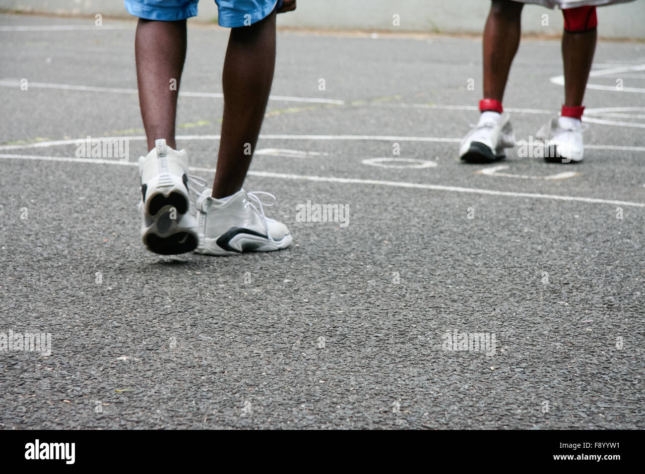 Due ragazzi neri giocando in uno Harlem pallacanestro, catena-link caselle di recinzione Foto Stock