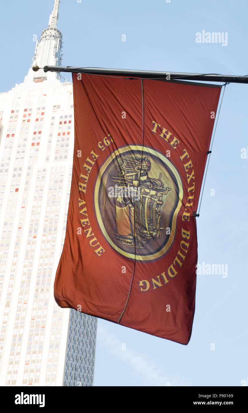 Edificio tessile bandiera sulla Quinta Avenue con l' Empire State Building in background, NYC Foto Stock