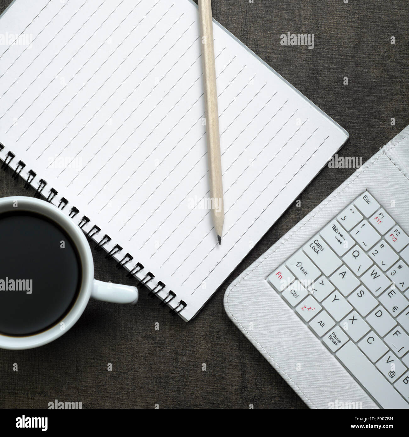 Blank notepad, laptop e la tazza di caffè su office tavolo in legno Foto Stock