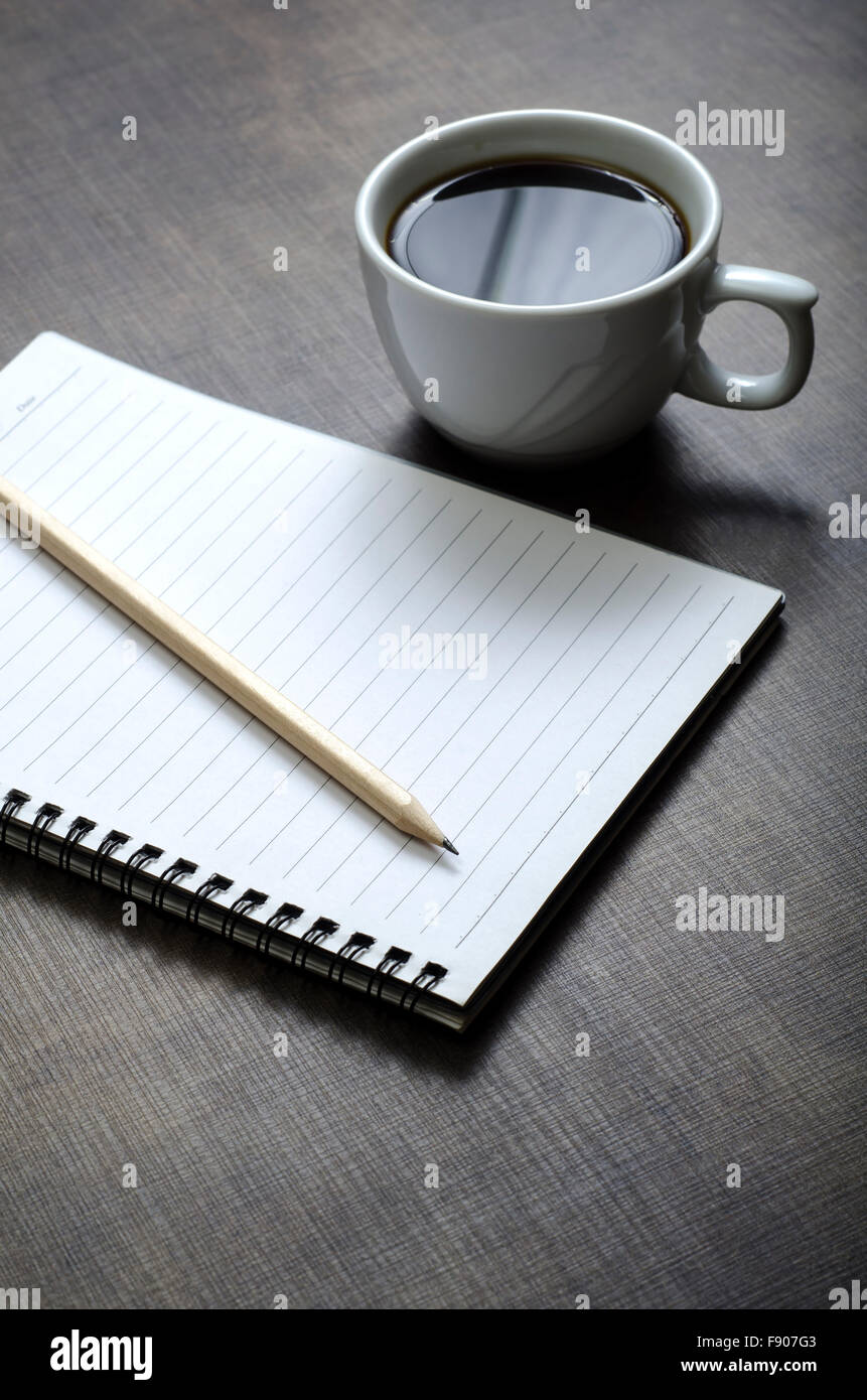 Aprire una casella vuota white notebook, penna e la tazza di caffè sulla scrivania Foto Stock