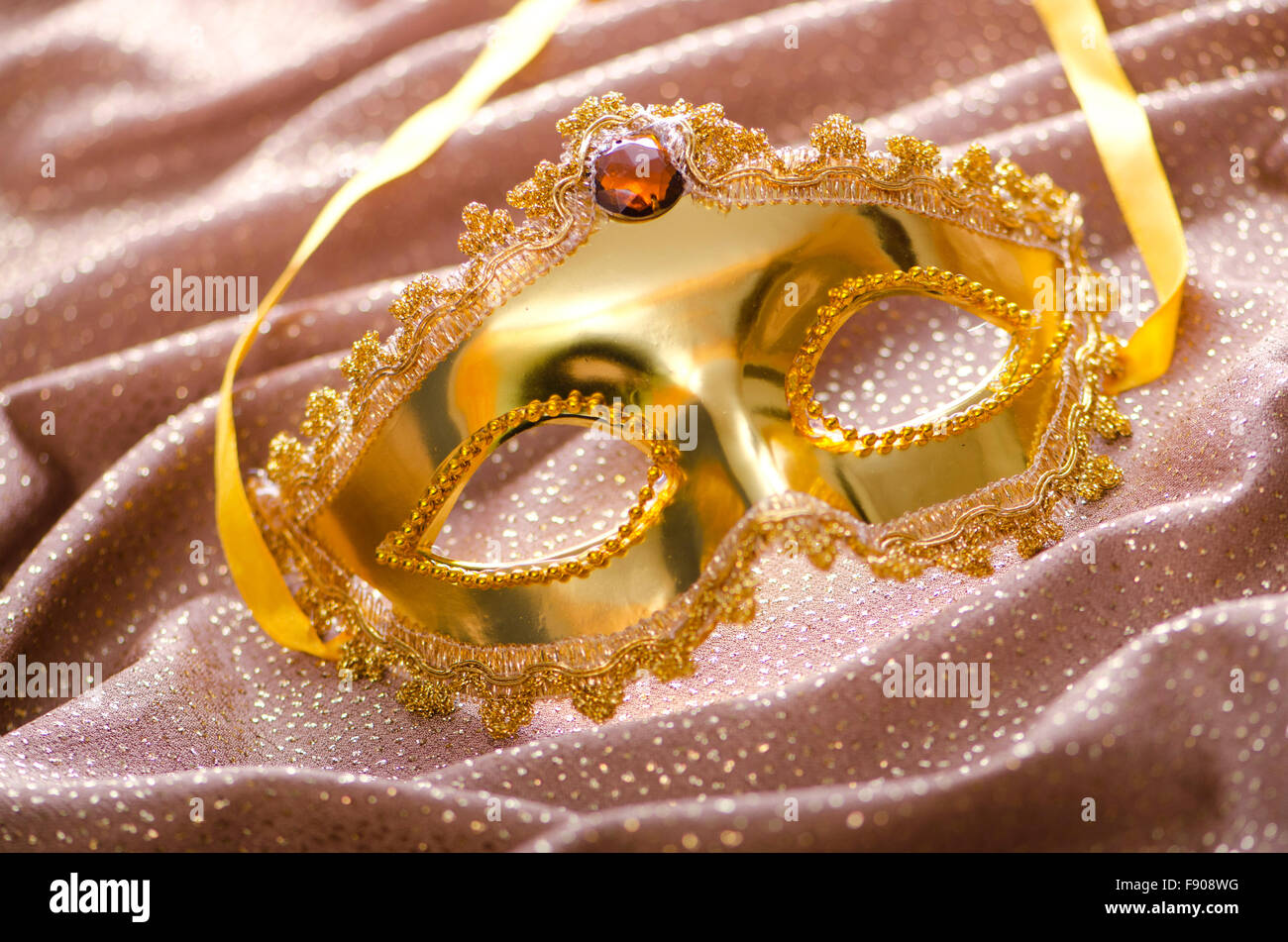 Maschera d'oro su sfondo satinato Foto Stock