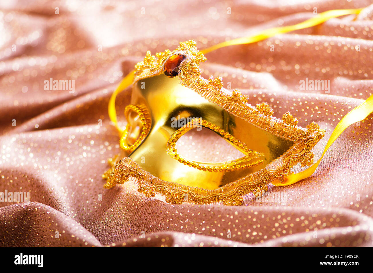 Maschera d'oro su sfondo satinato Foto Stock