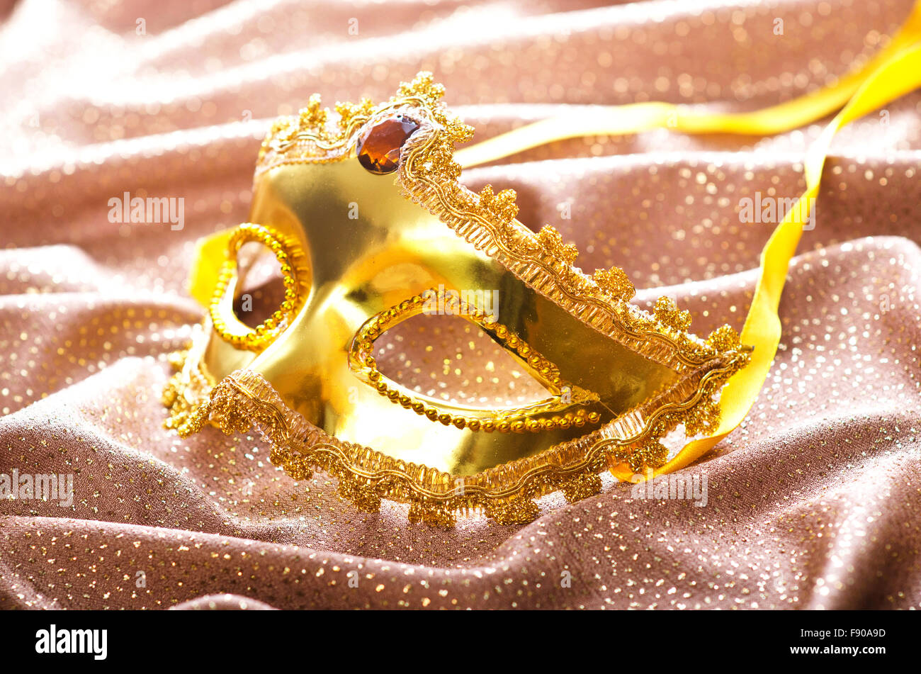Maschera d'oro su sfondo satinato Foto Stock