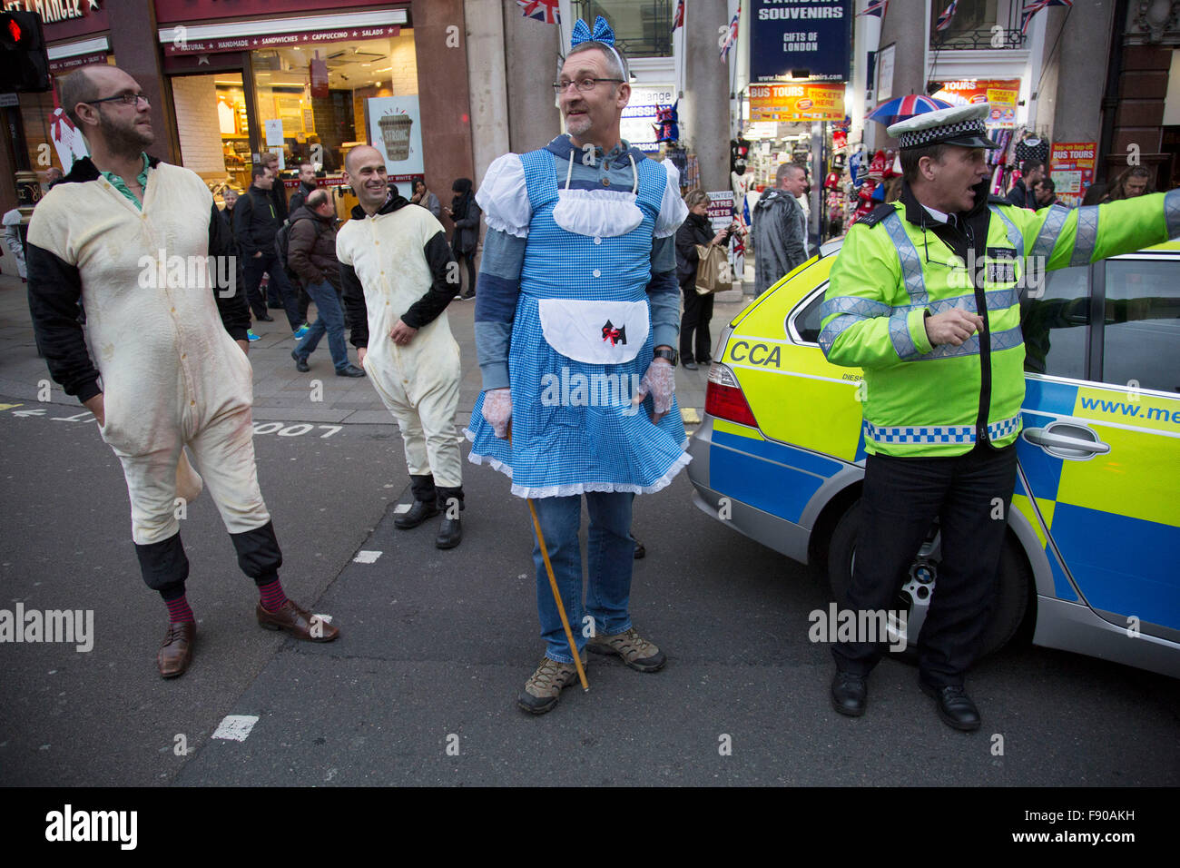 Londra, Regno Unito. Dodicesimo Dicembre, 2015. Gruppo di amici per un giorno di Natale nel centro di Londra, Regno Unito. Vestito come Bo Peep e un gregge di pecore, dopo la famosa filastrocca. Qui Bo Peep chiede se la polizia hanno visto le sue pecore, come egli non riesce a trovare loro. La polizia si uniscono in per divertimento. Credito: Michael Kemp/Alamy Live News Foto Stock