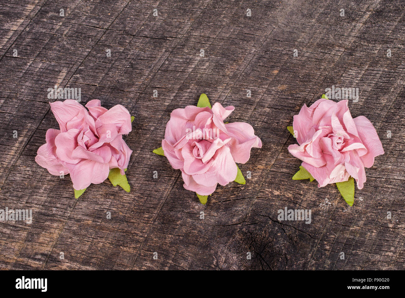 Tre rose rosa sul vecchio fienile del legno Foto Stock