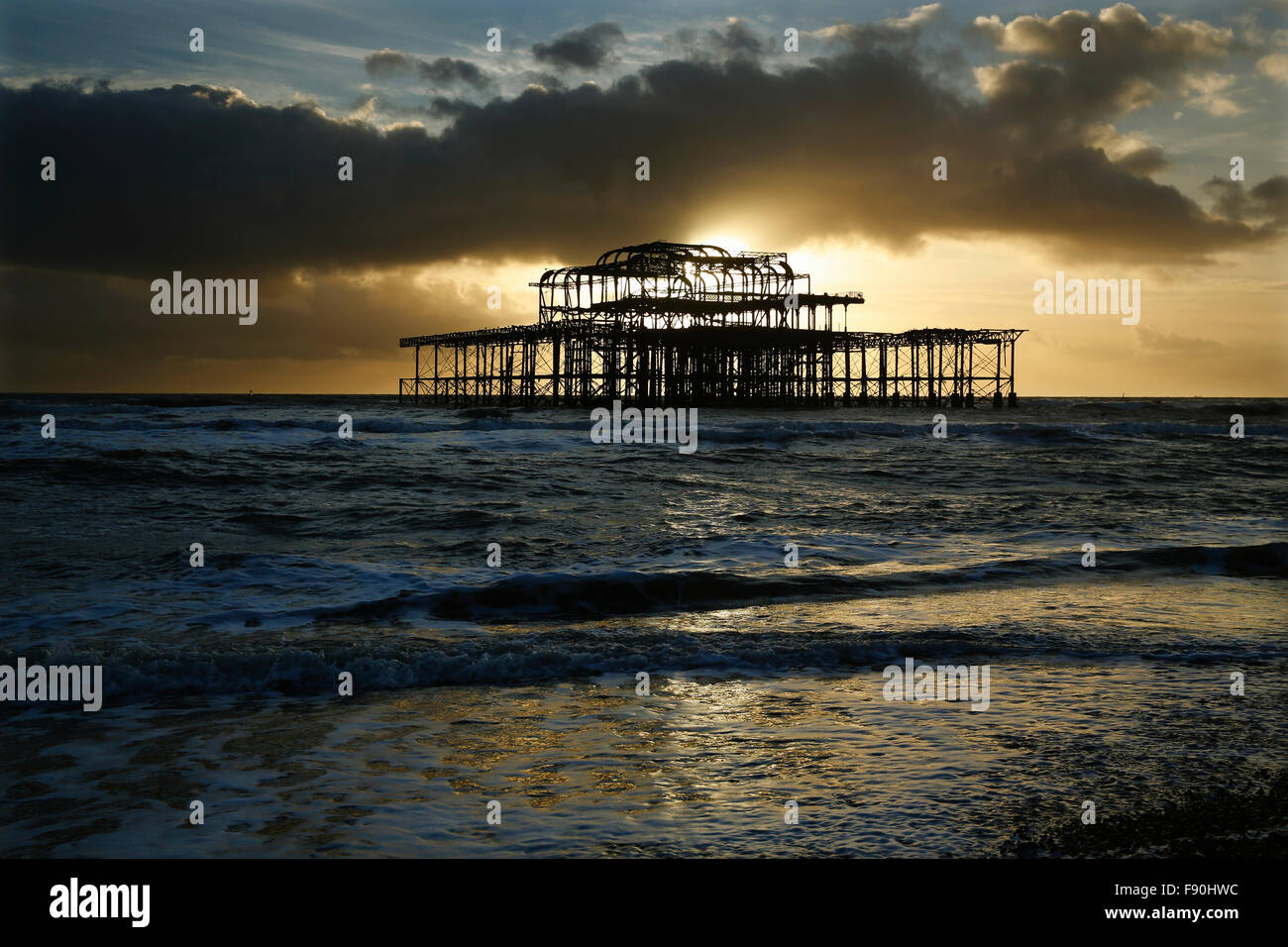 Pomeriggio di sole risplende attraverso il cielo in tempesta dietro il Molo di Ponente a Hove vicino a Brighton, Sussex, Regno Unito Foto Stock
