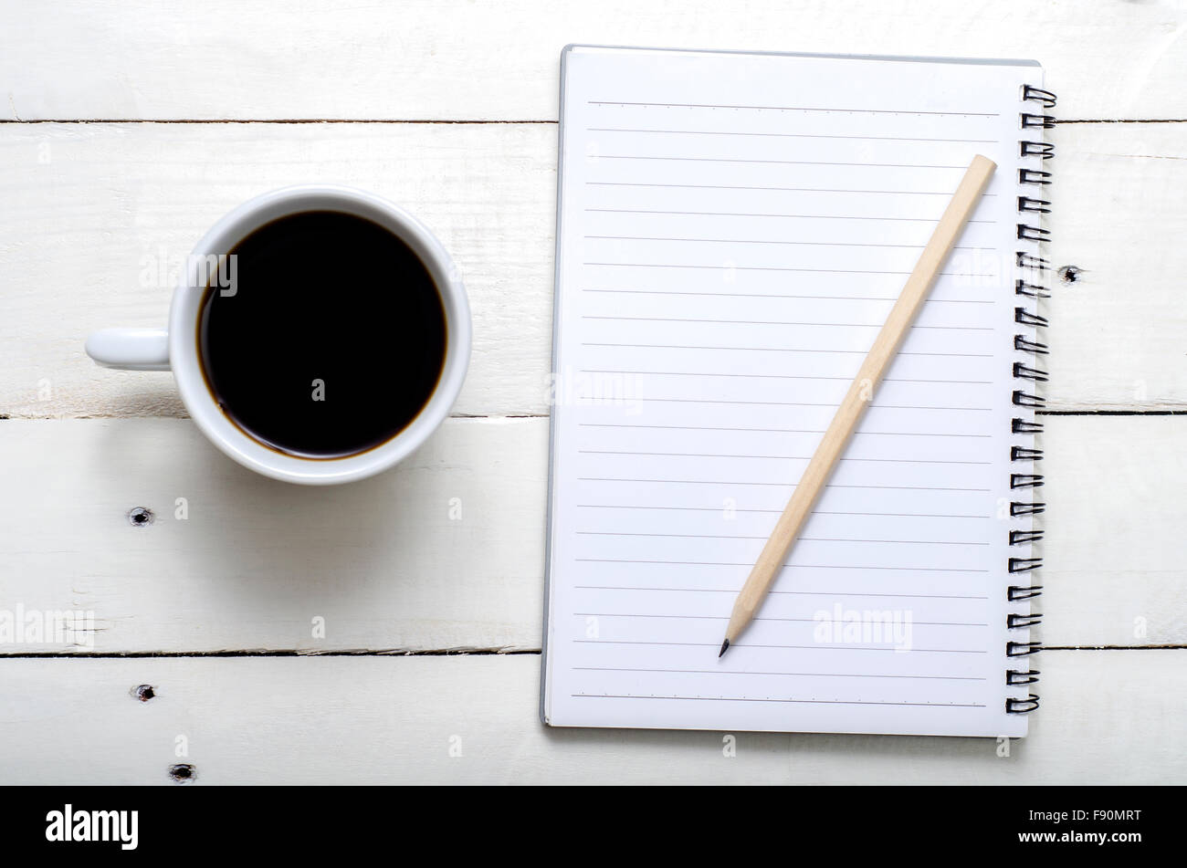 Caffè caldo tempo con notebook e matita su bianco tavolo in legno Foto Stock
