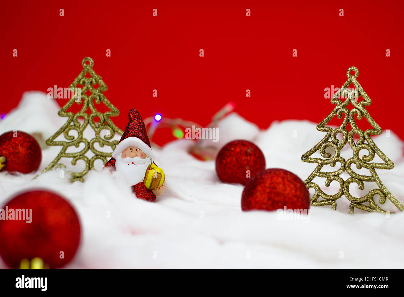 Babbo Natale figurine con dono su sfondo rosso Foto Stock